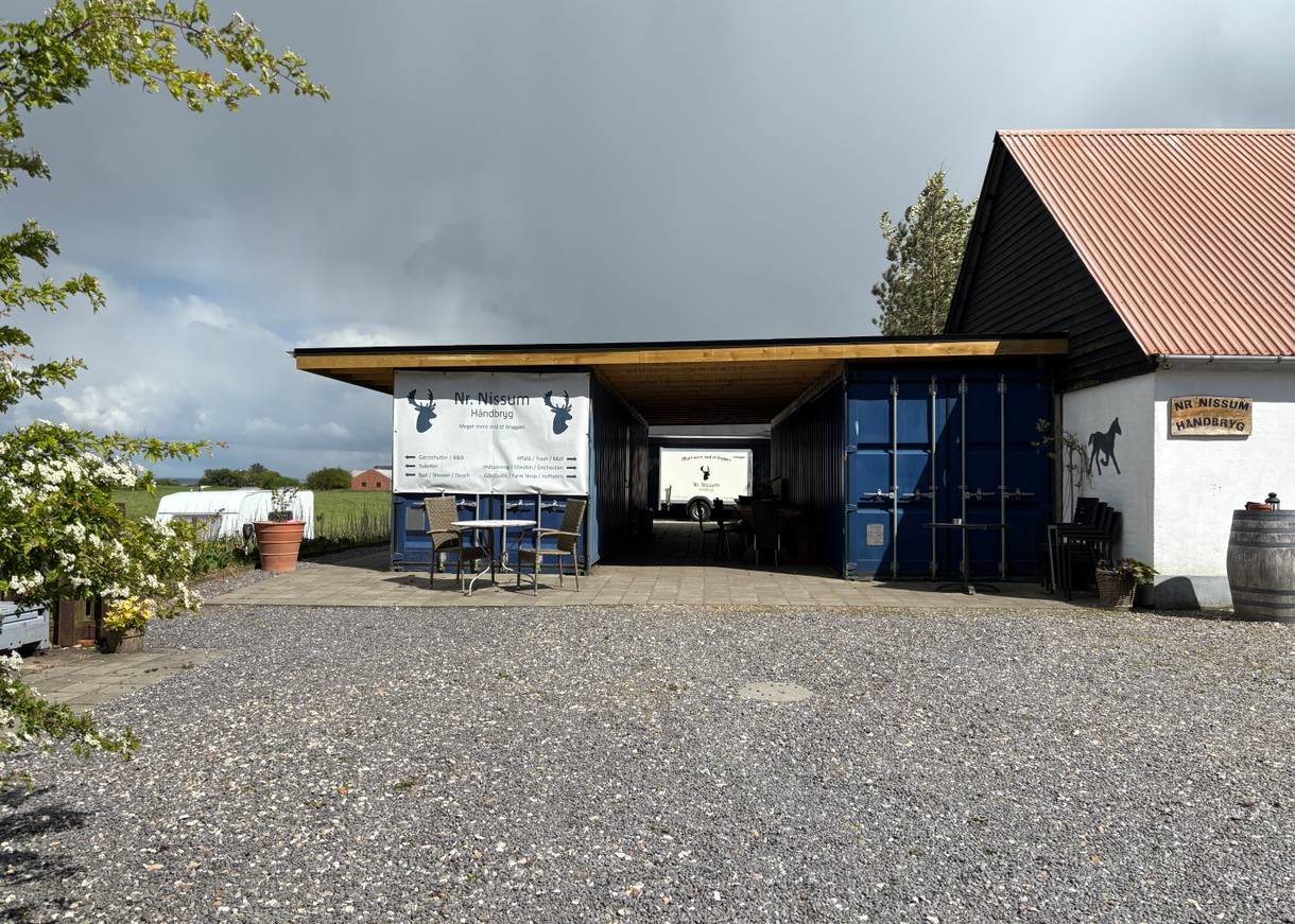 Hof mit zwei blaue Schiffscontainer und Schilder, die auf einer kleinen Brauerei hinweisen