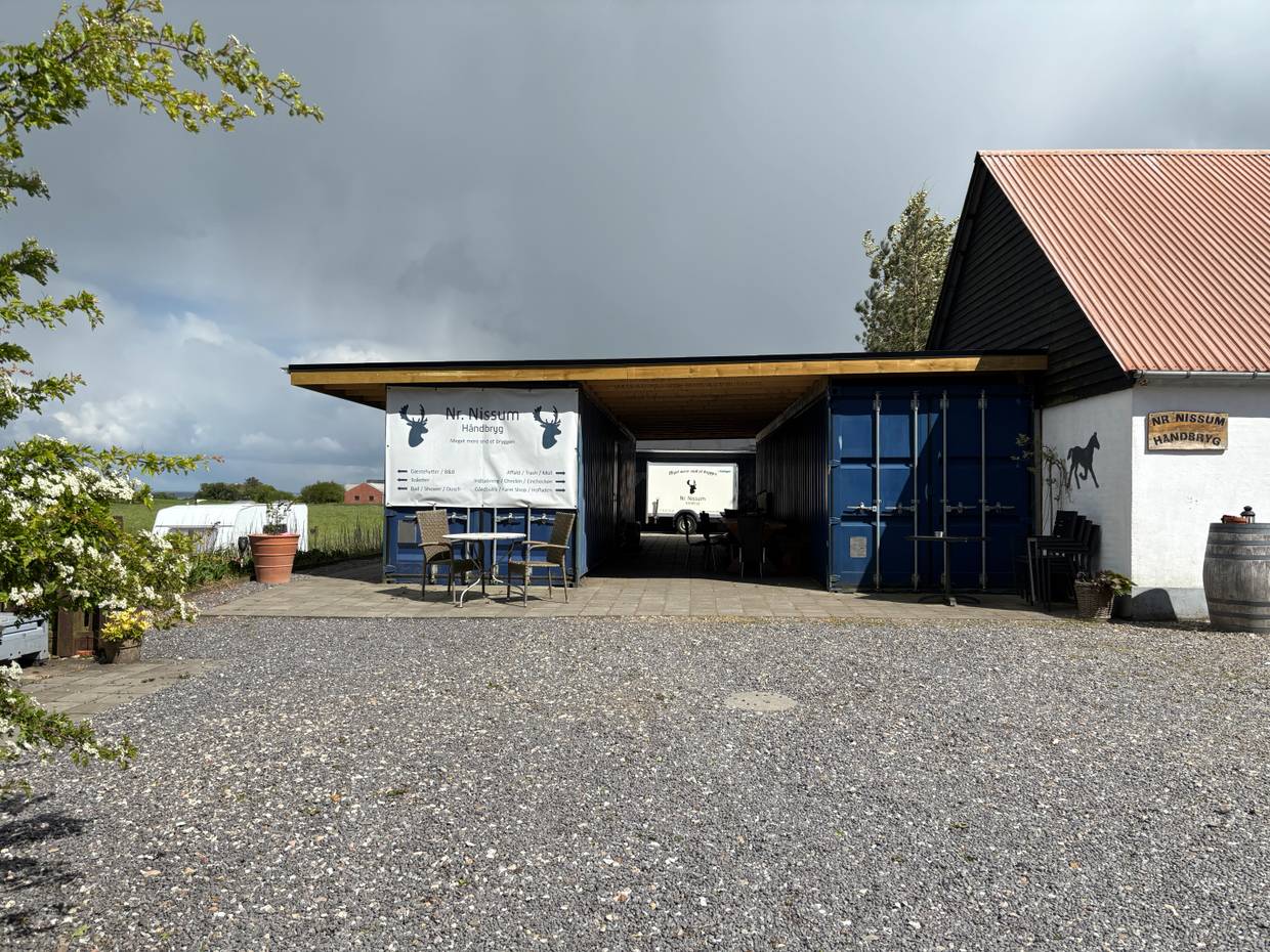 Hof mit zwei blaue Schiffscontainer und Schilder, die auf einer kleinen Brauerei hinweisen