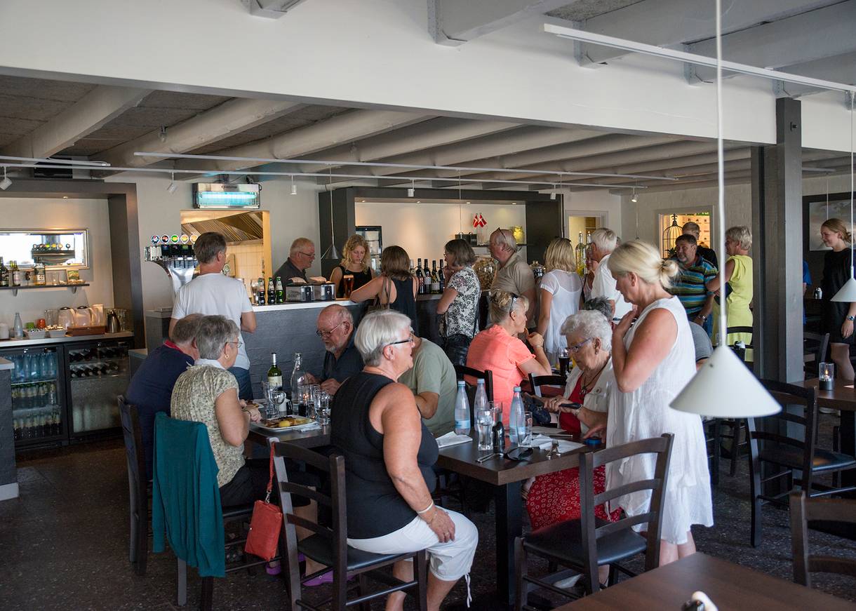 Blick in ein Restaurant mit sommerlich gekleideten Gästen