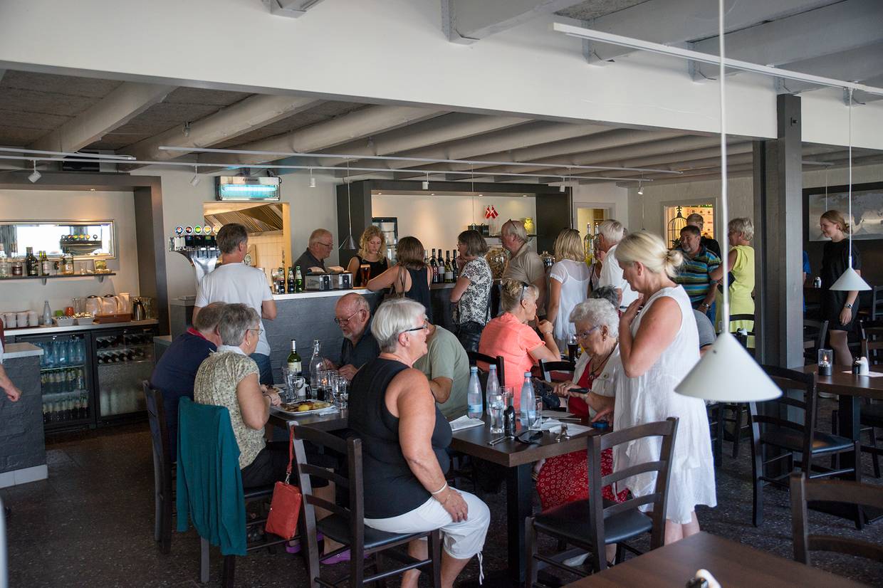 Blick in ein Restaurant mit sommerlich gekleideten Gästen