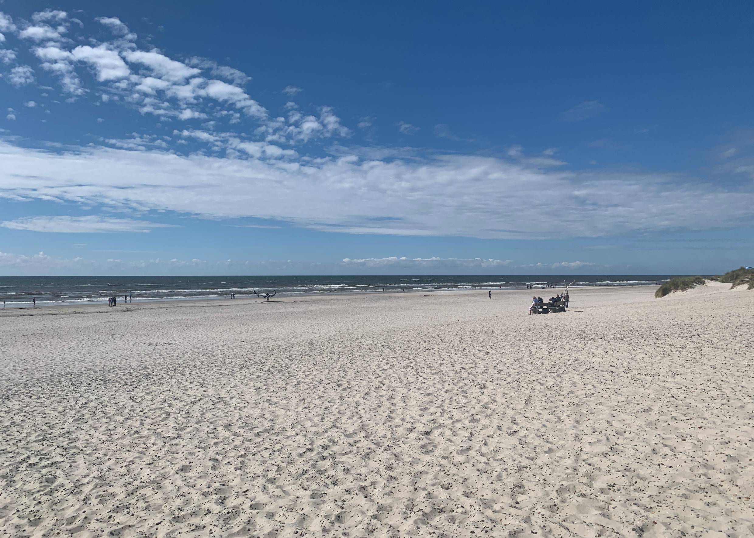 Blick über einen breiten Strand mit weißen Sand