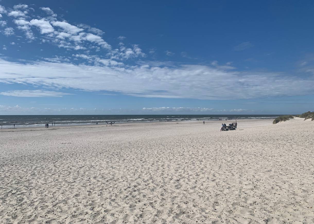 Blick über einen breiten Strand mit weißen Sand