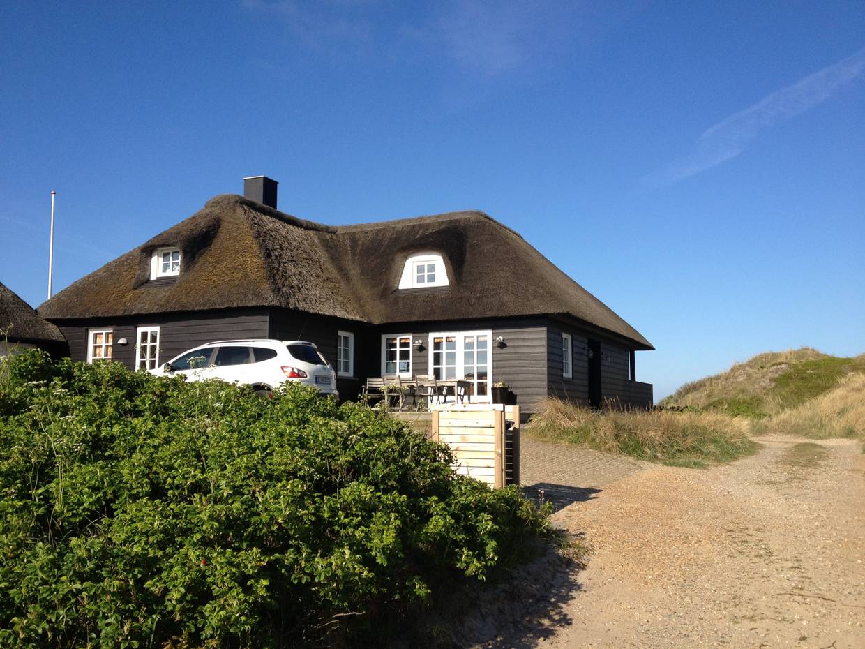 Scharzes Ferienhaus auf einer Düne an der Nordsee in Dänemark