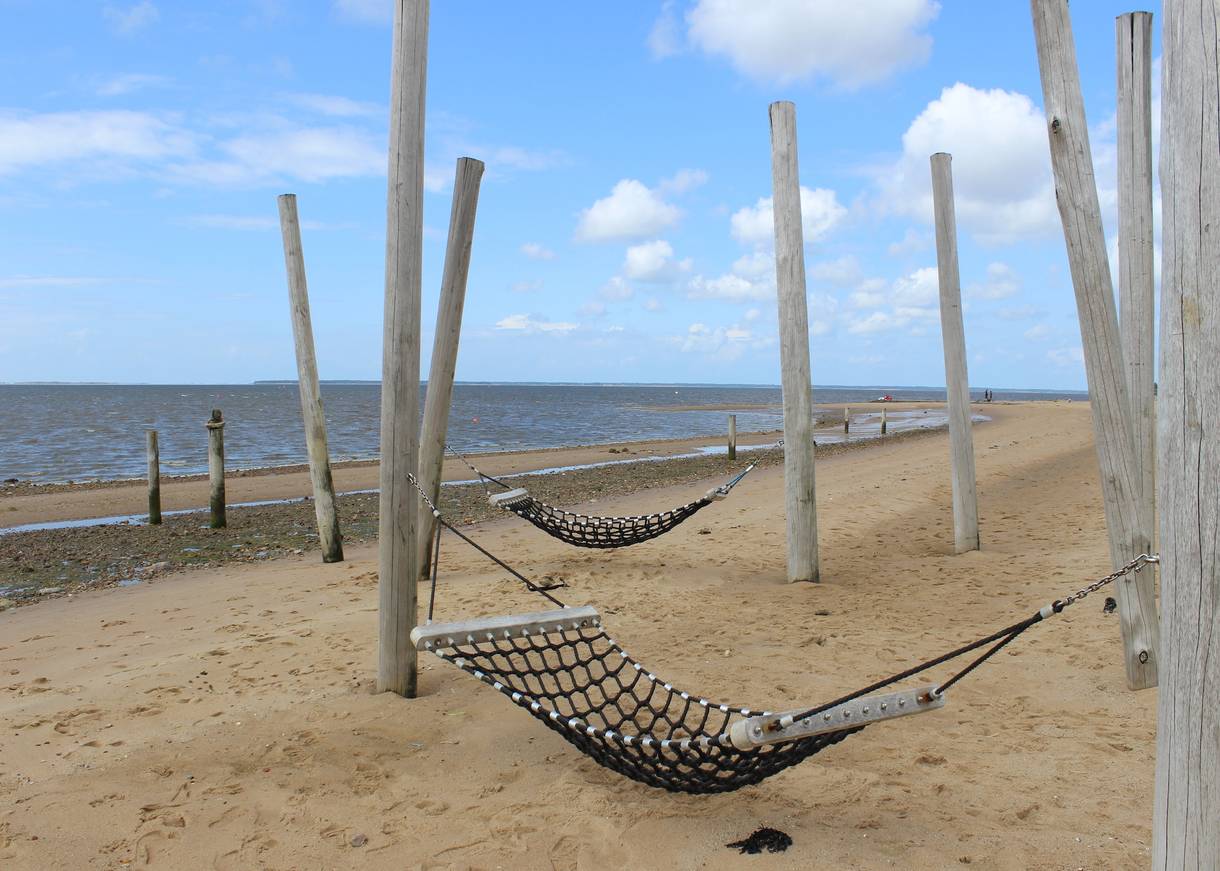 Hängematten zwischen Holzpfählen am Strand