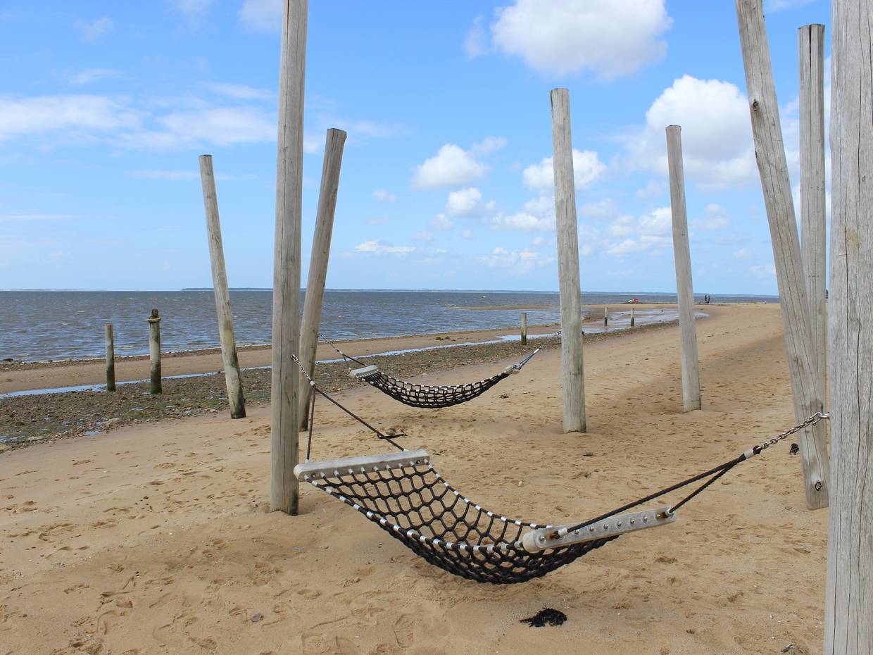 Hängematten zwischen Holzpfählen am Strand