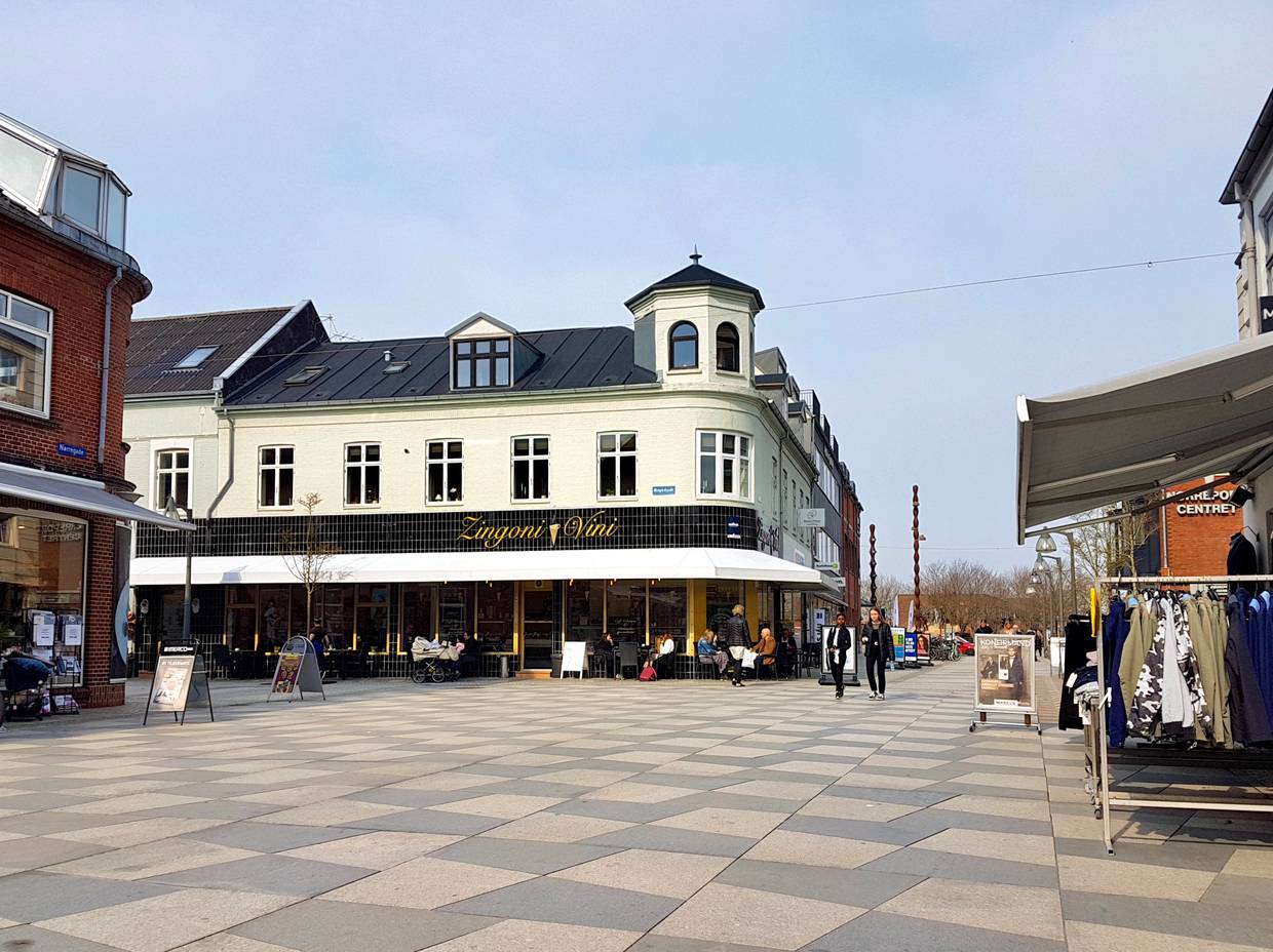 Schwarz-weiß gepflasterter Platz mit einem Café im Design der 50er Jahre