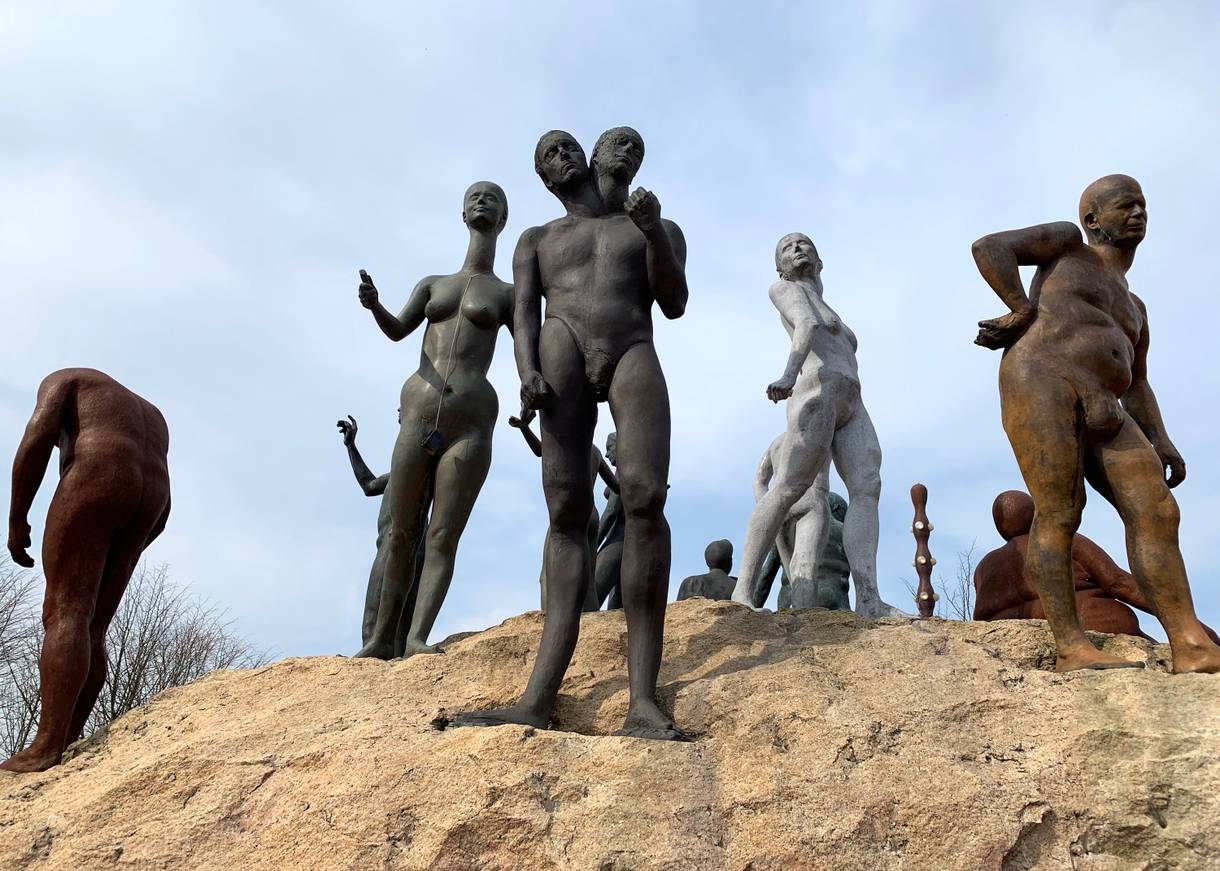 Verschiedenen Menschen aus Bronze auf einerm kleinen Hügel