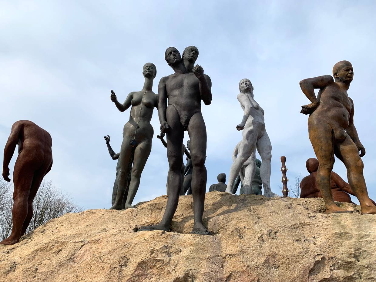 Verschiedenen Menschen aus Bronze auf einerm kleinen Hügel