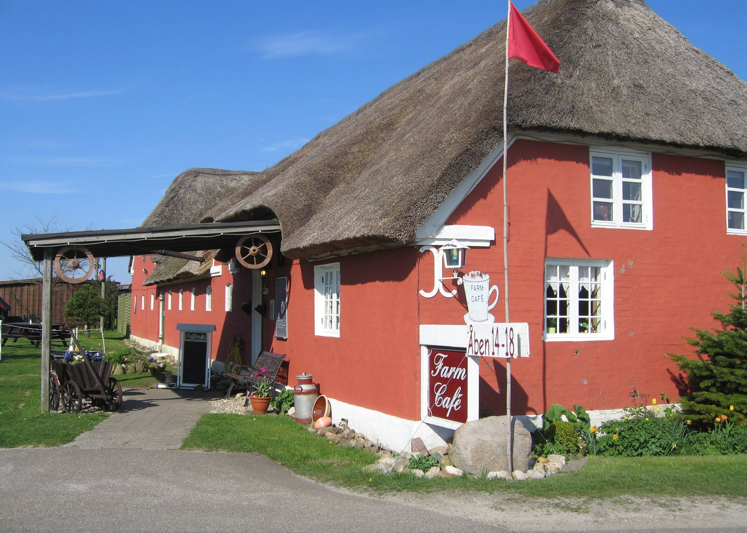 Rotes, reetgedecktes Gebäude mit weißen Fenstern