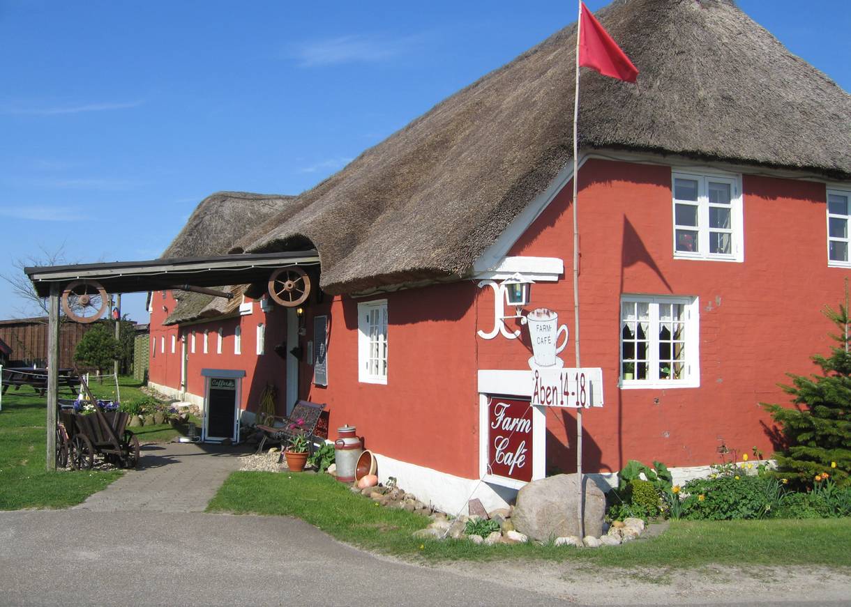 Rotes, reetgedecktes Gebäude mit weißen Fenstern