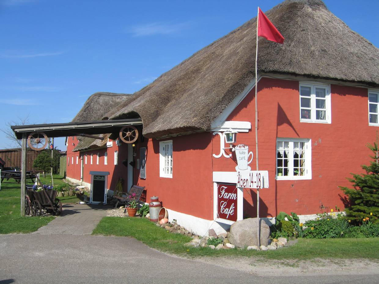 Rotes, reetgedecktes Gebäude mit weißen Fenstern