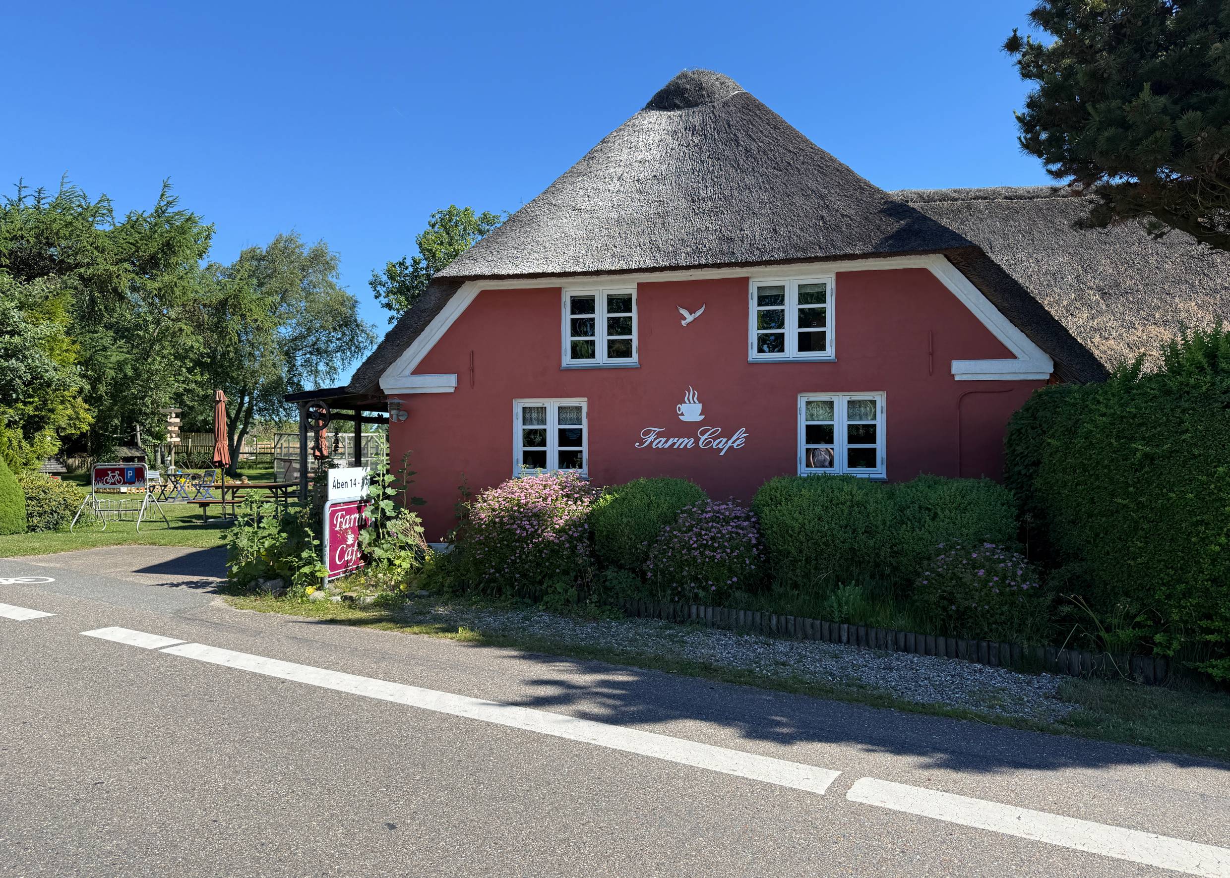 Rotes, reetgedecktes Gebäude mit weißen Fenstern