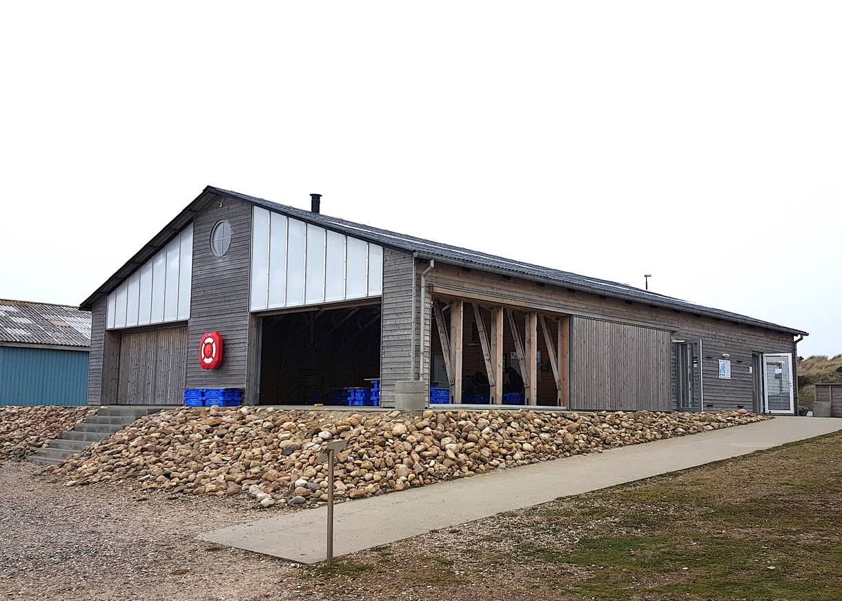 Flacher Holzbau mit einem überdachten Picknickbereich