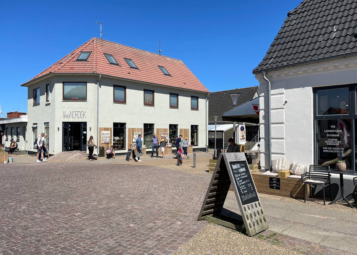 Häuserfronten mit Geschäften und ein Café an einem Runden Platz