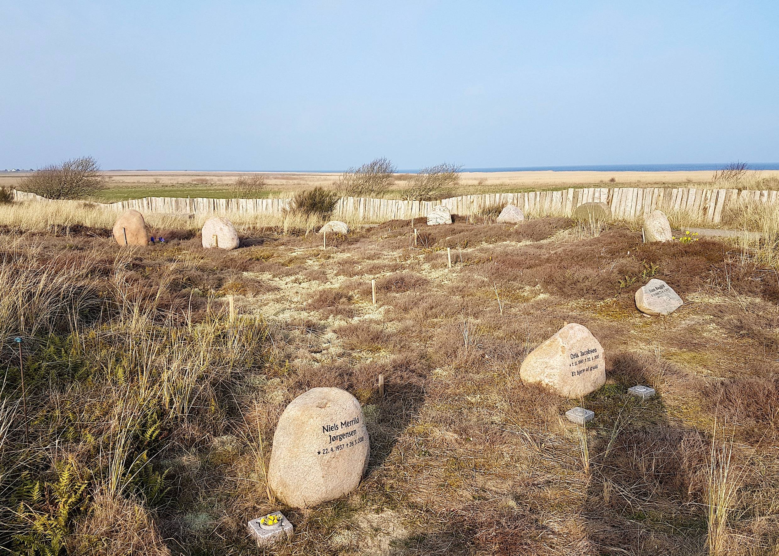 Gräber mit kleinen Felssteinen, dazwischen naturbelassene Heide