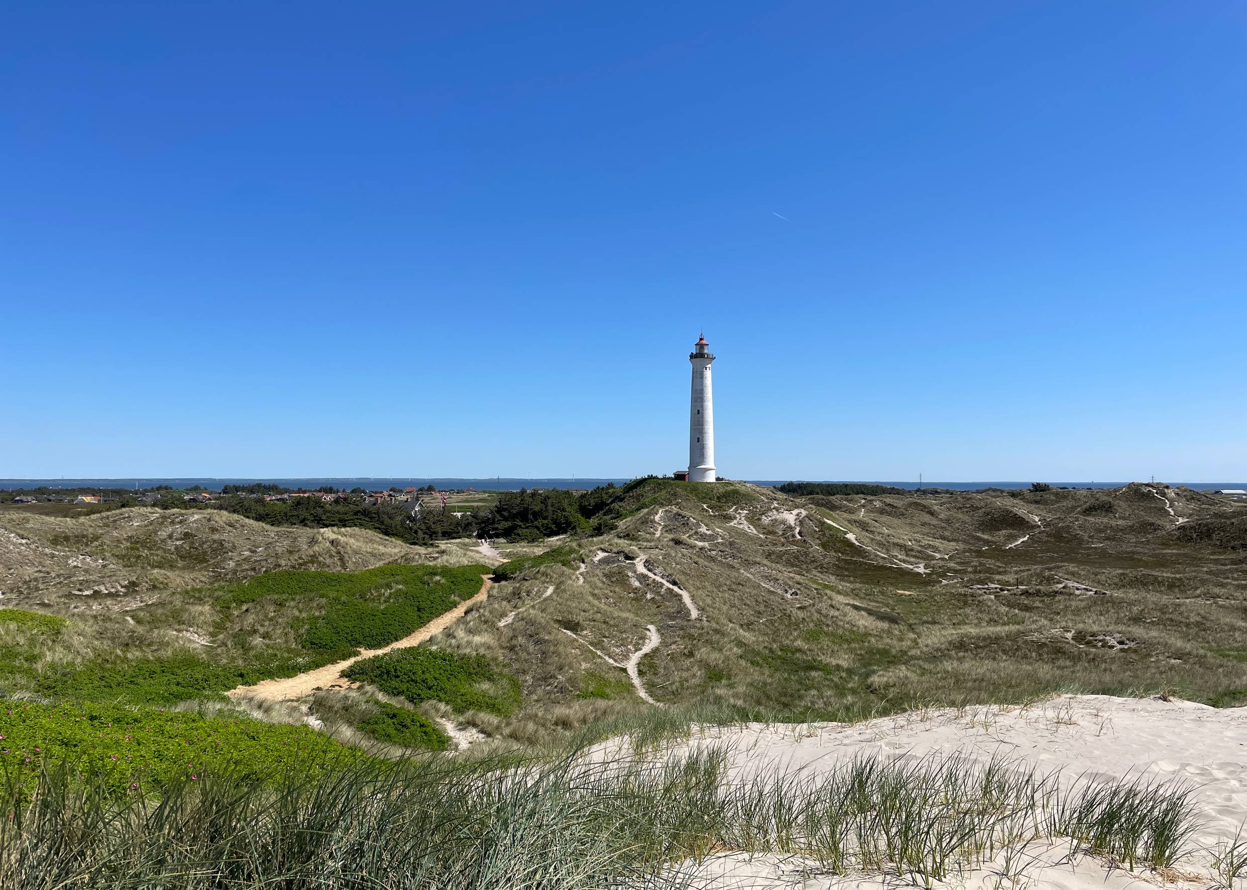 Leuchtturm in einer unbebauten Dünenlandschaft