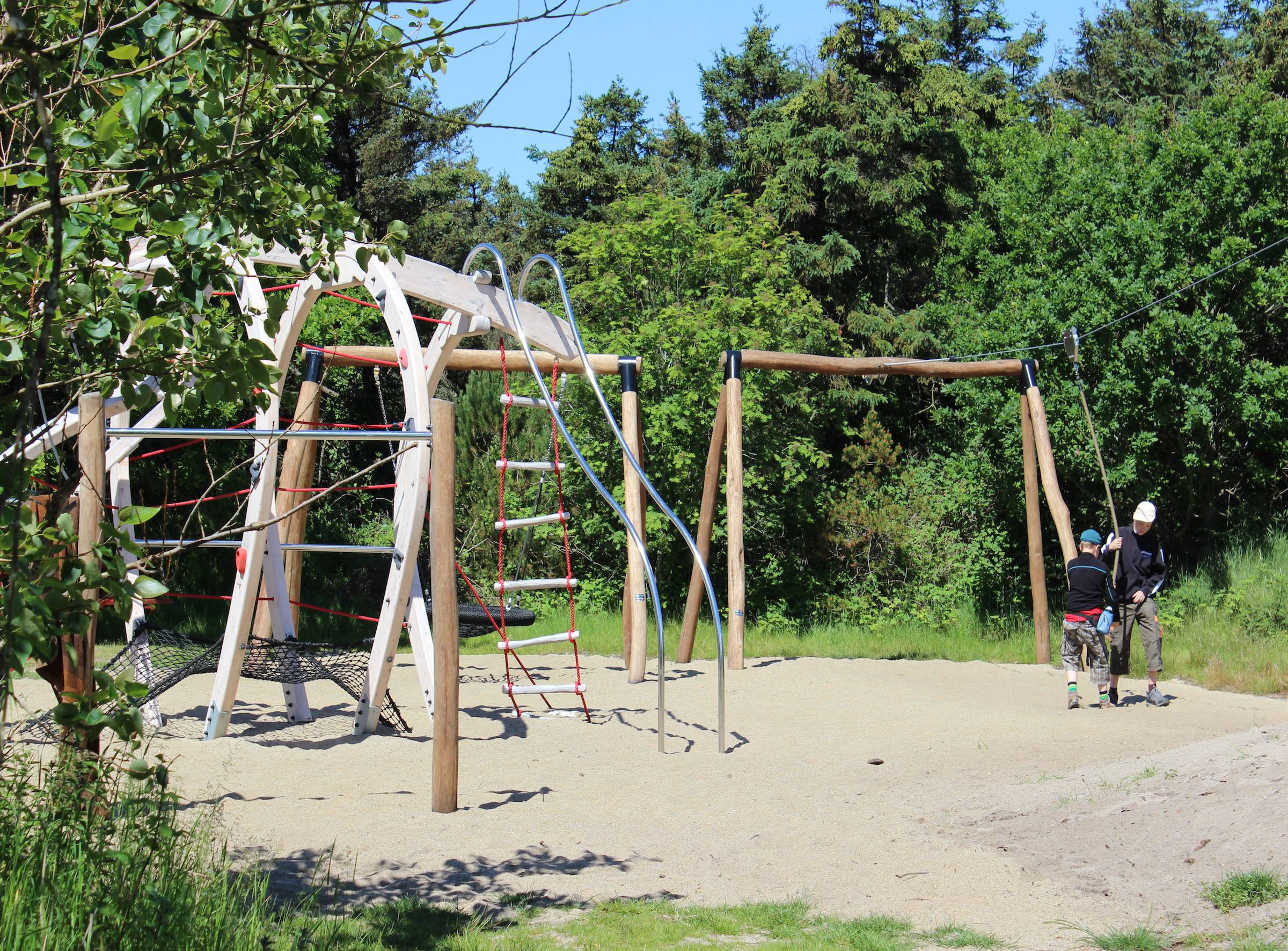 Neuer Spielplatz mit Klettergerüsten zwischen Bäumen