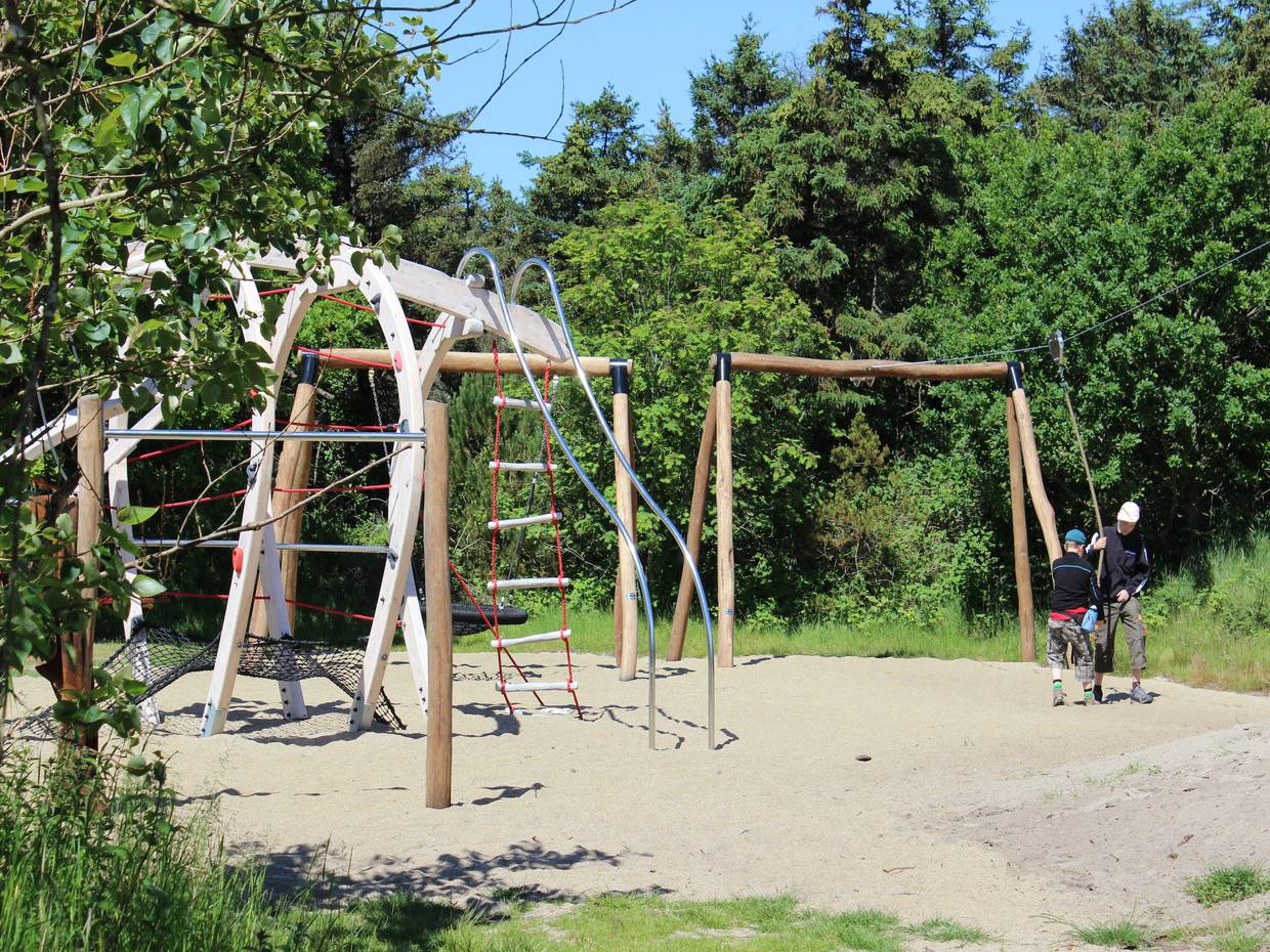 Neuer Spielplatz mit Klettergerüsten zwischen Bäumen