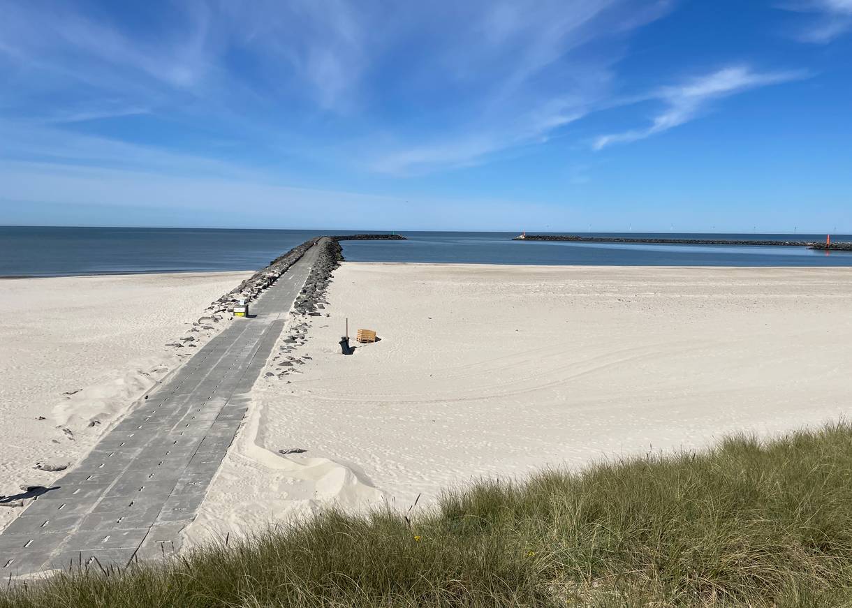 Breiter Strand zwischen zwei Molen, von der Düne aus gesehen