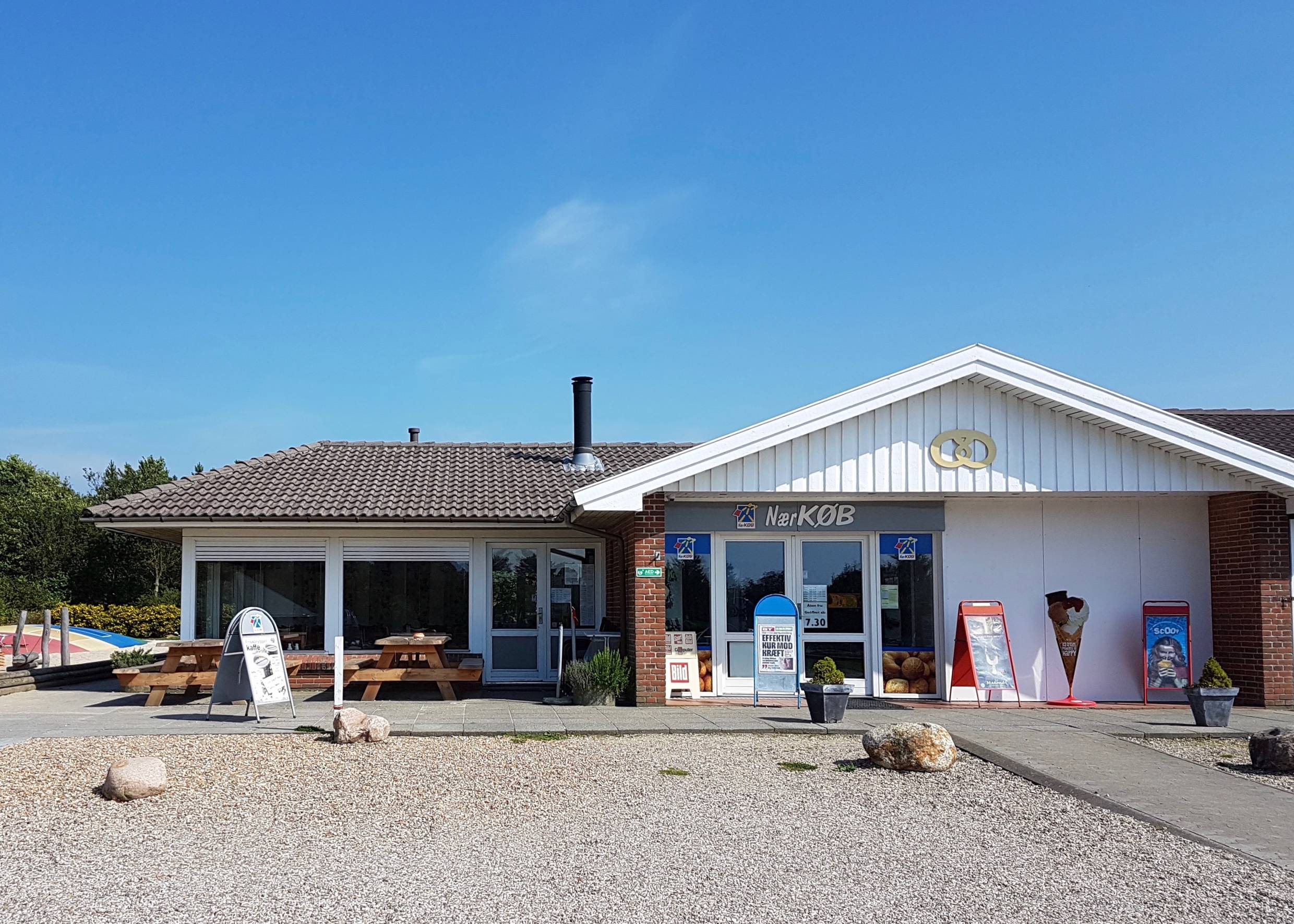 Kleines Lebensmittelgeschäft mit Picknickbänken vor der Tür