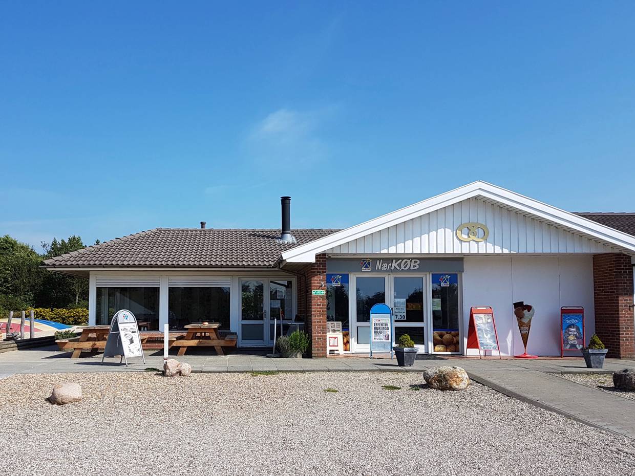 Kleines Lebensmittelgeschäft mit Picknickbänken vor der Tür