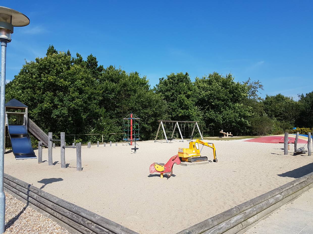 Spielplatz mit Sand, Hüpfkissen und allerlei Spielgeräten