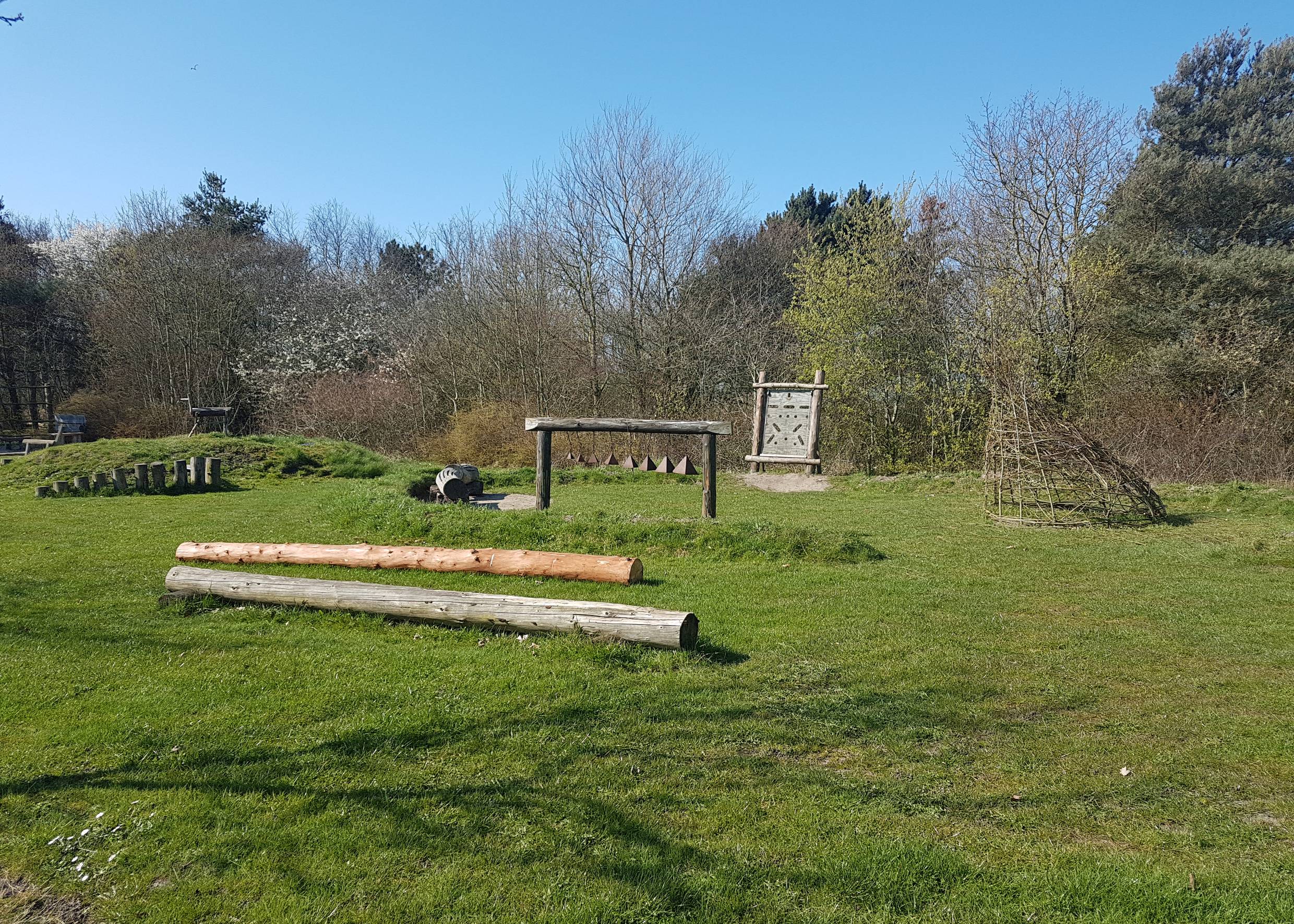 Naturspielplatz mit Holzgerüsten auf einer Wiese