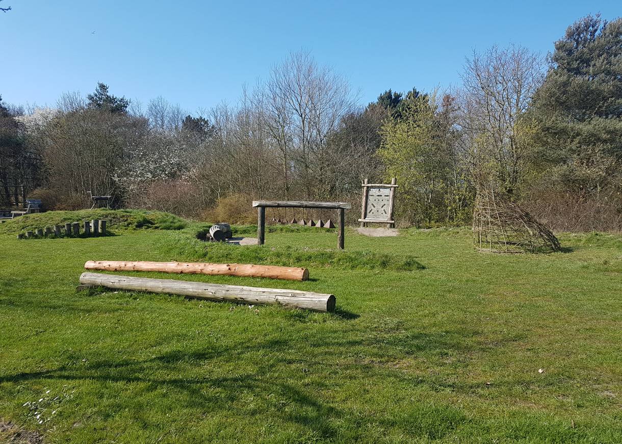 Naturspielplatz mit Holzgerüsten auf einer Wiese
