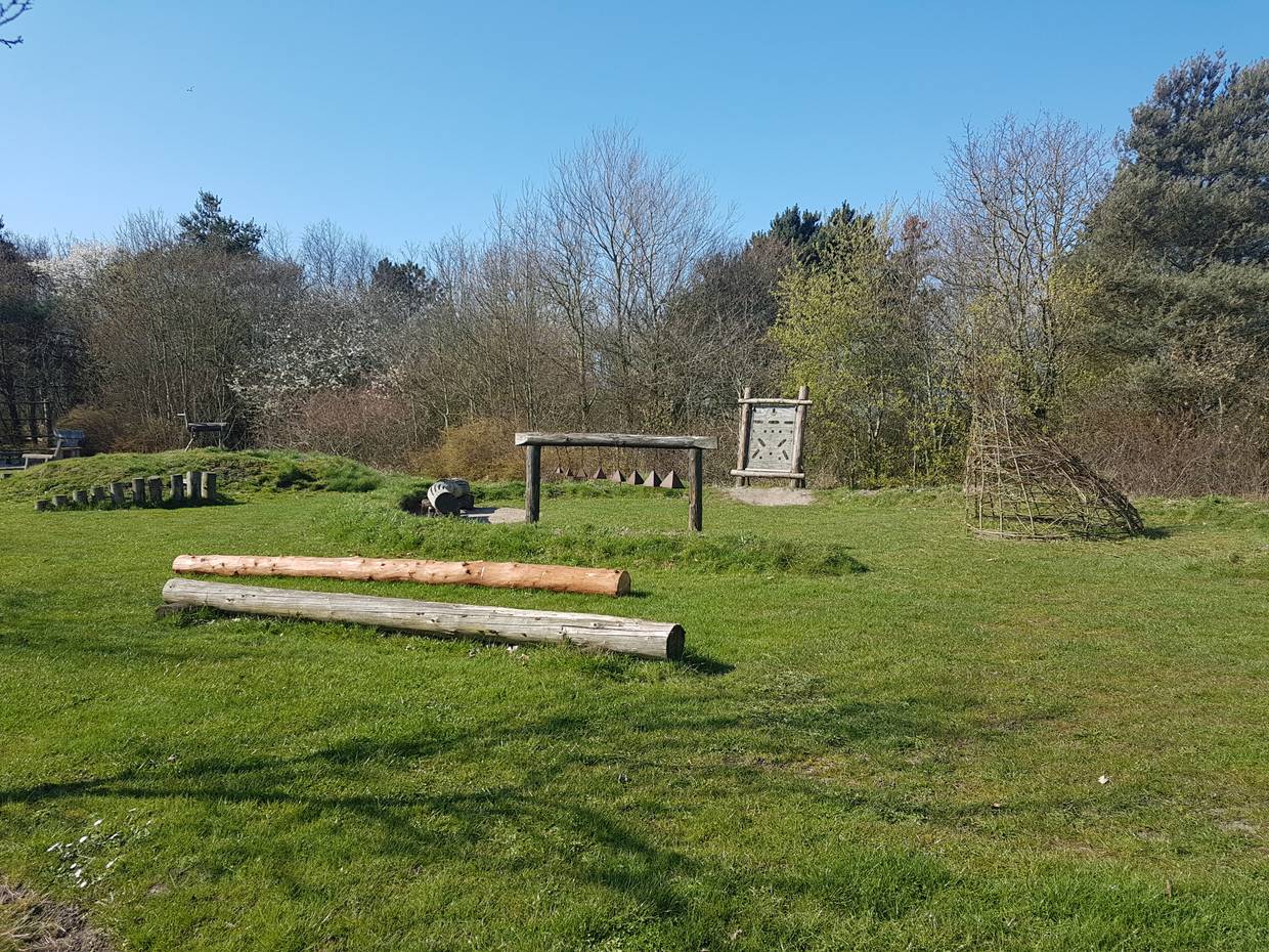 Naturspielplatz mit Holzgerüsten auf einer Wiese