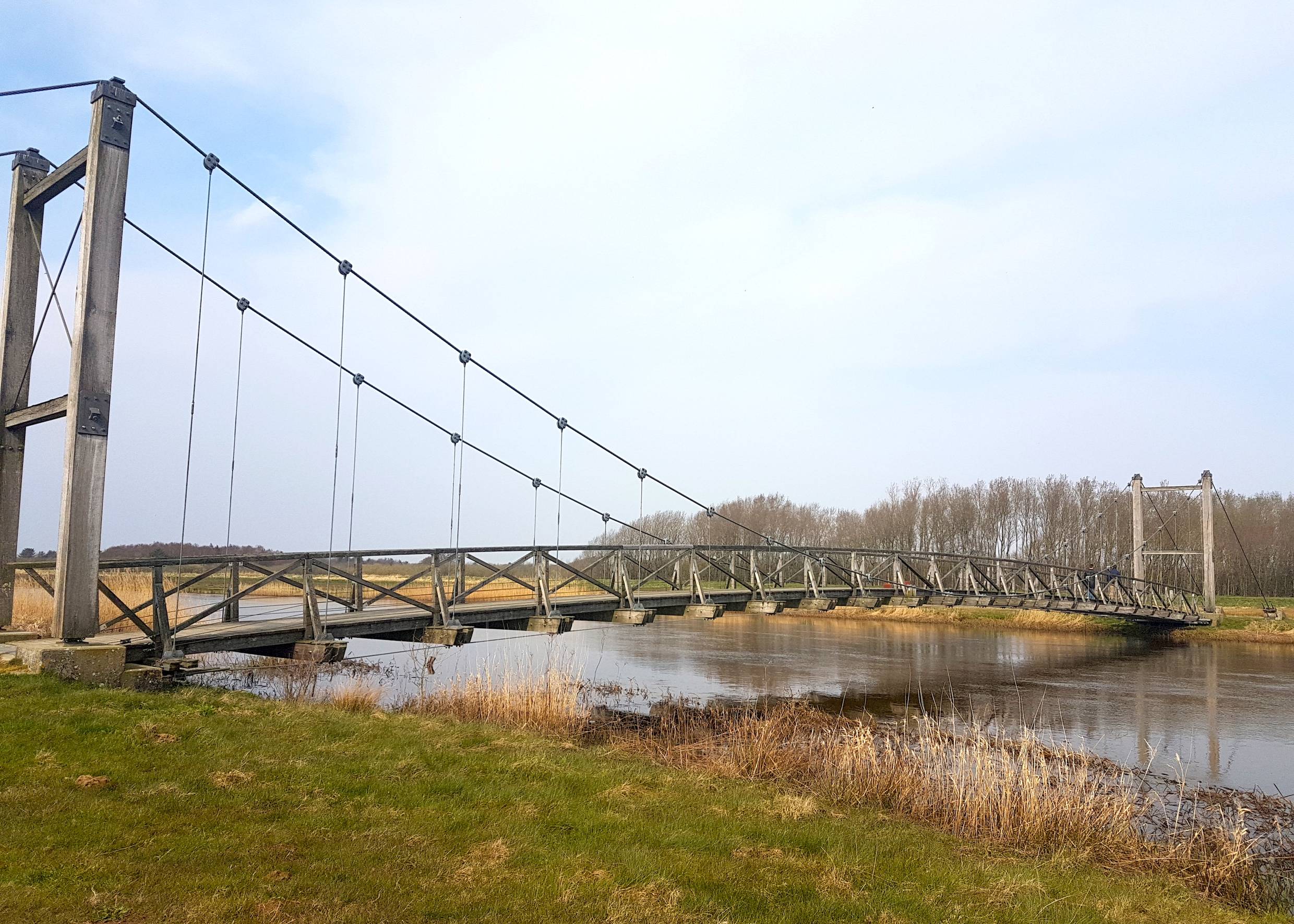 Hölzerne Hängebrücke über einen Fluss
