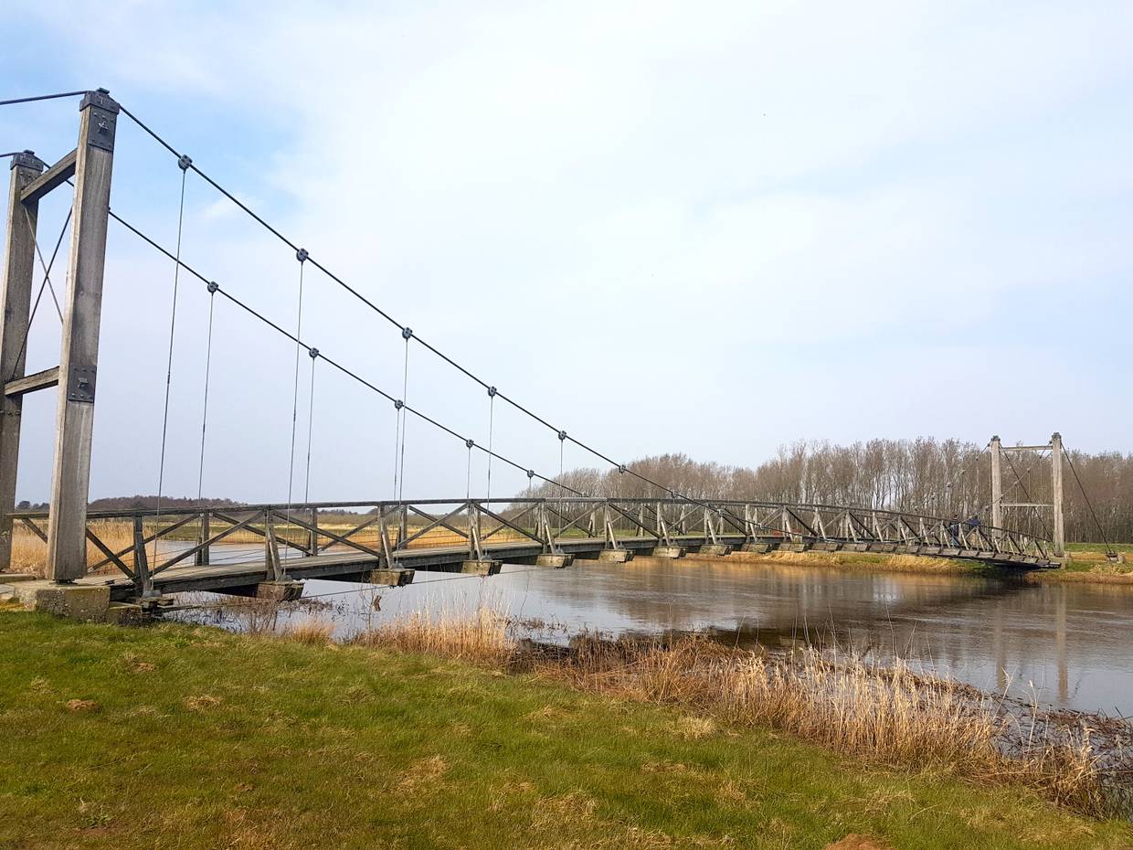 Hölzerne Hängebrücke über einen Fluss
