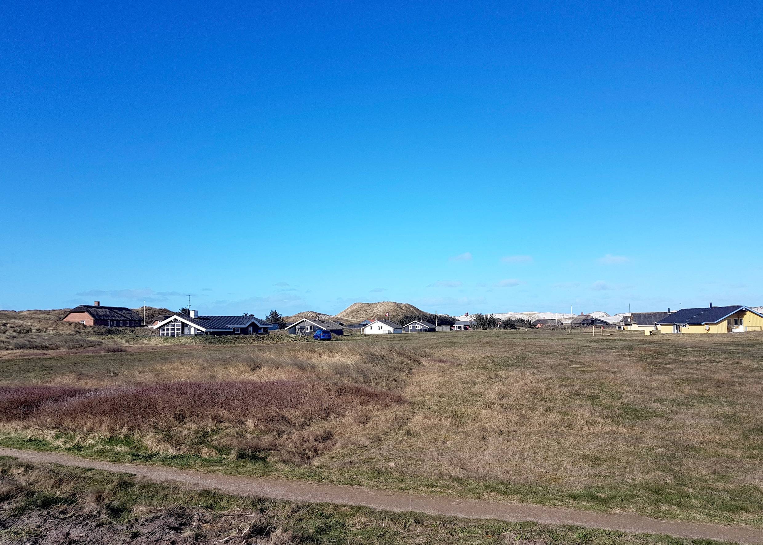 Vereinzelte Ferienhäuser vor den Dünen