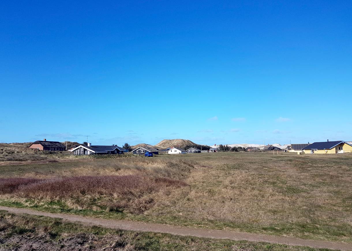 Vereinzelte Ferienhäuser vor den Dünen