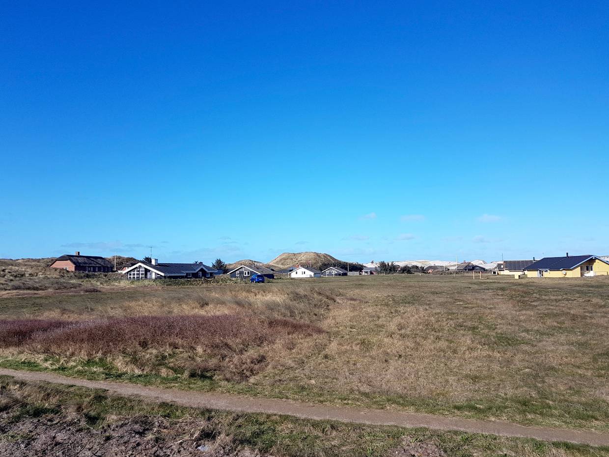 Vereinzelte Ferienhäuser vor den Dünen