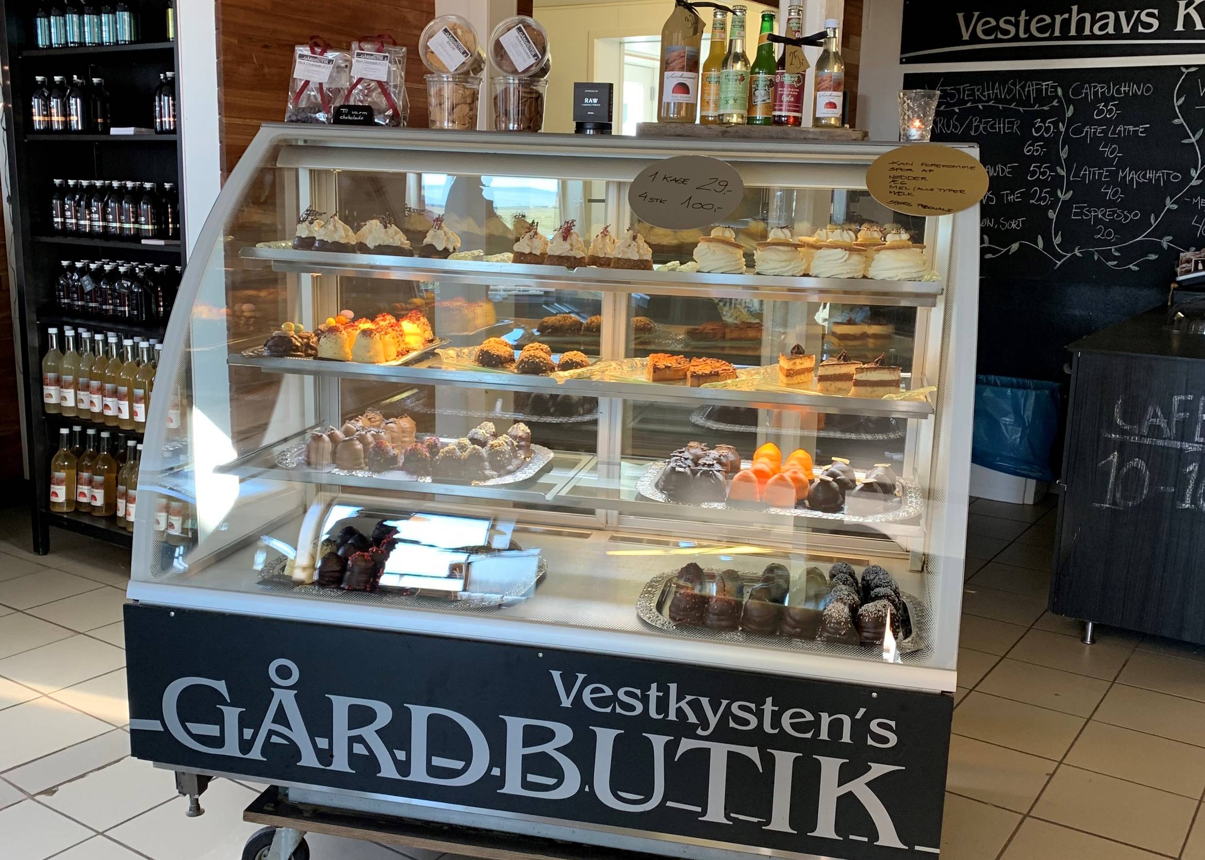 Kleiner Glastresen mit Sahnekuchen, dahinter Getränke im Regal