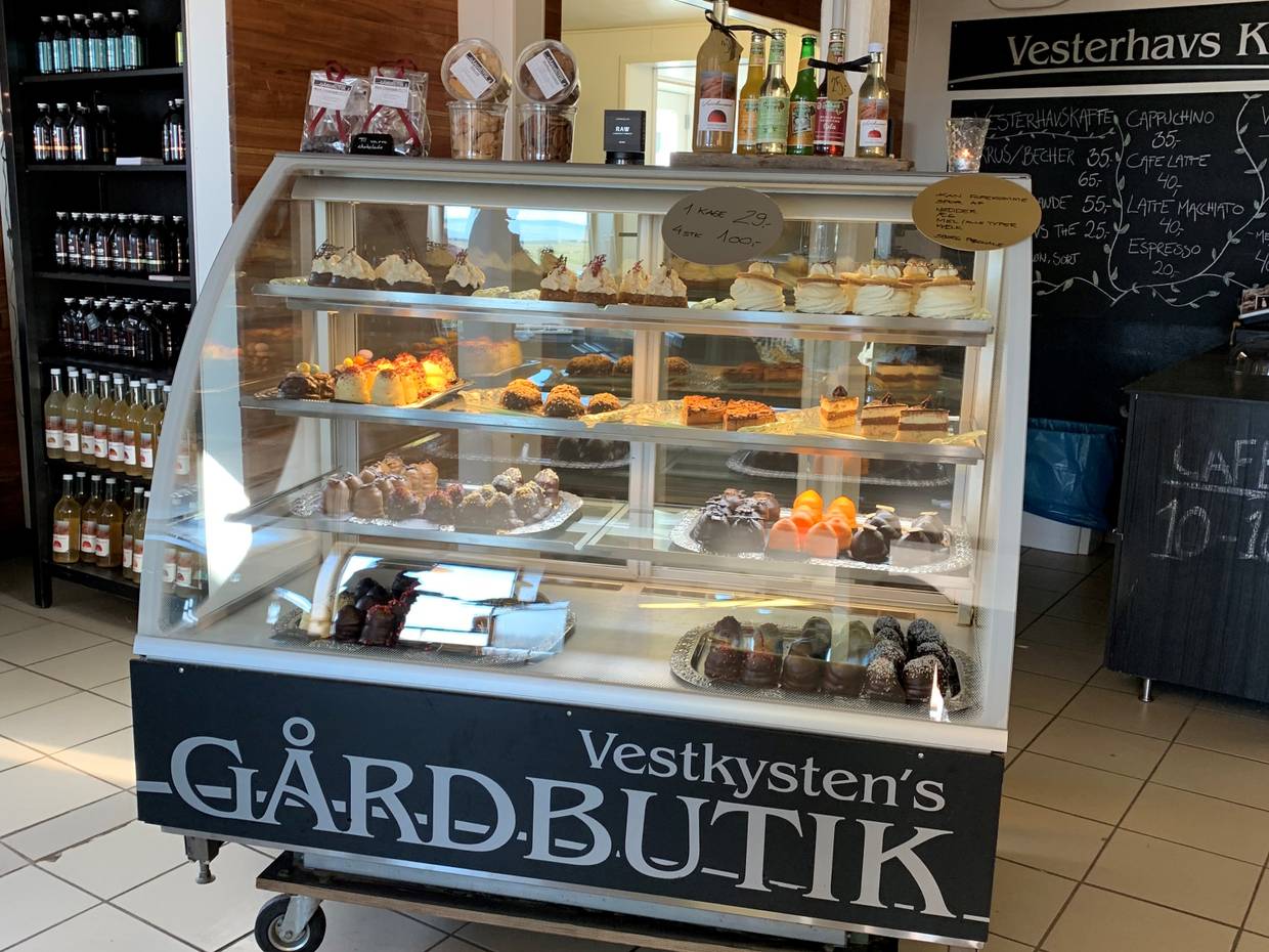 Kleiner Glastresen mit Sahnekuchen, dahinter Getränke im Regal