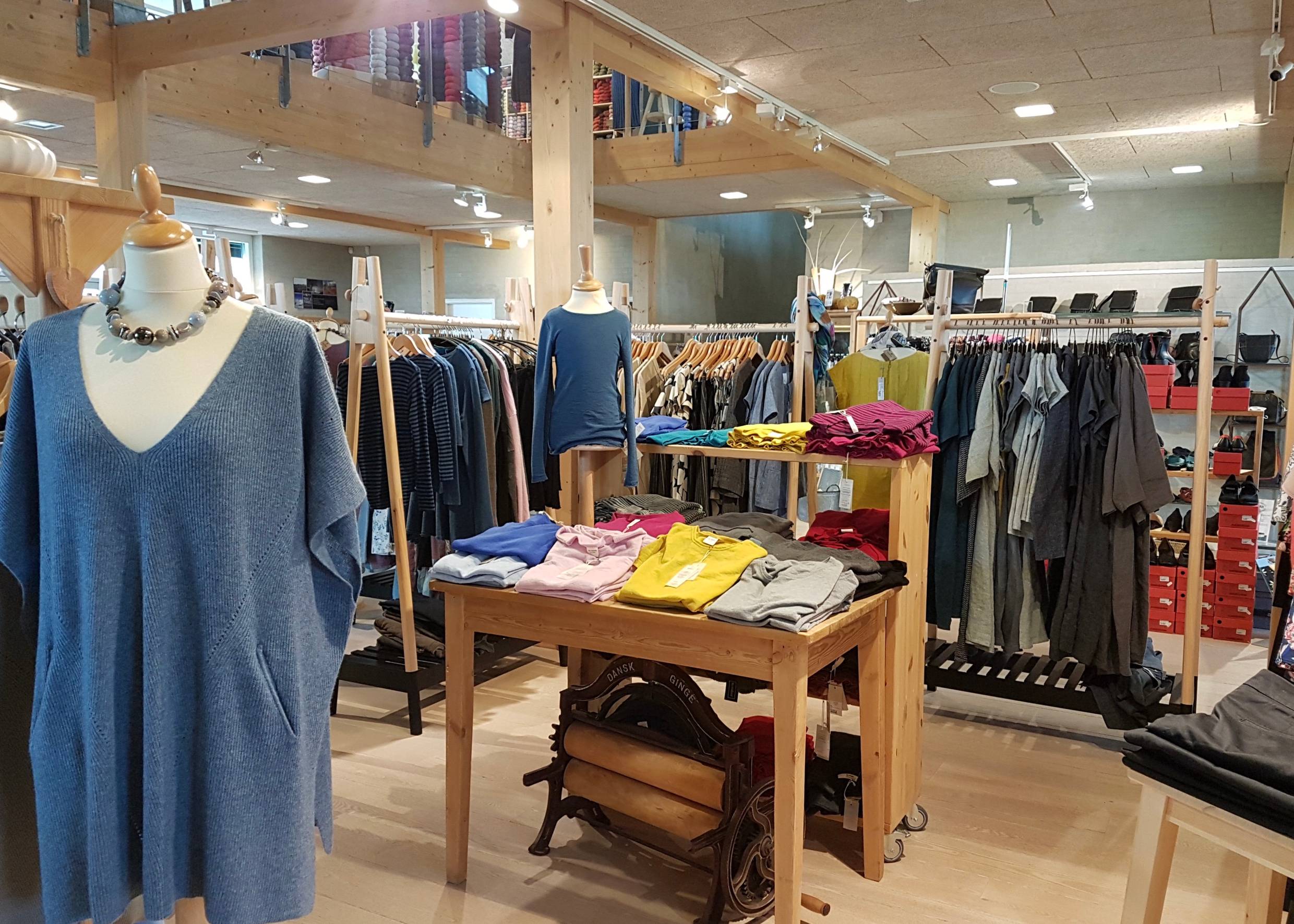 Kleiderständer und ein Tisch mit bunten Shirts und Pullovern