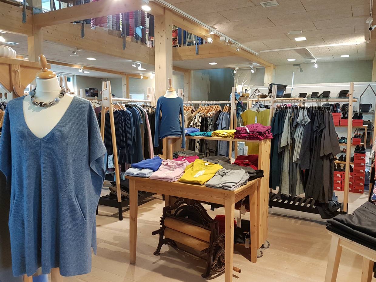 Kleiderständer und ein Tisch mit bunten Shirts und Pullovern