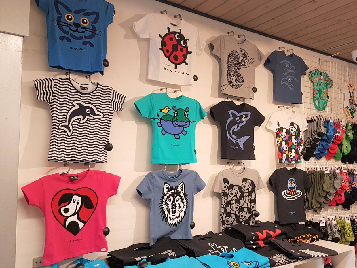 Eine Wand mit bunten T-Shirts von Bo Bendixen