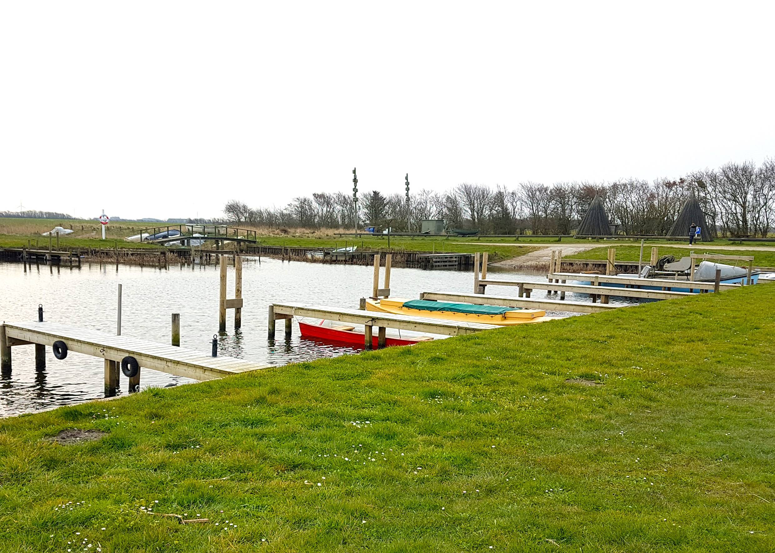 Kleiner Hafen mit bunten Booten und Bänken am Ufer