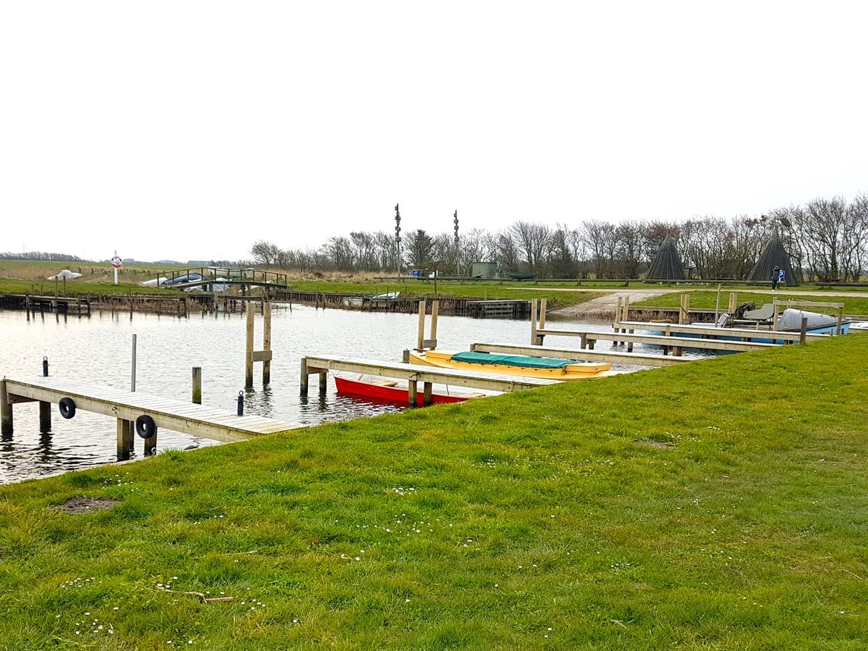 Kleiner Hafen mit bunten Booten und Bänken am Ufer