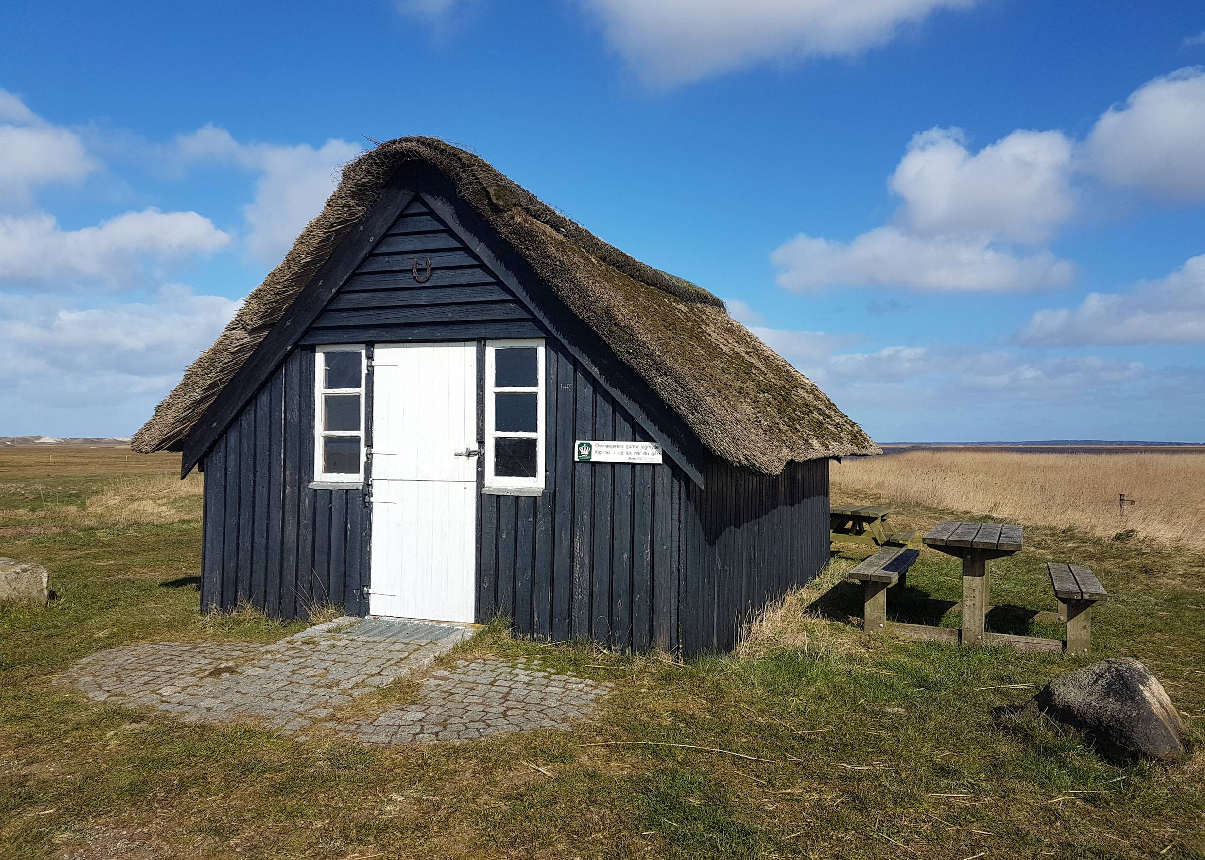 Kleine Reetdachhütte mit Picknickbank