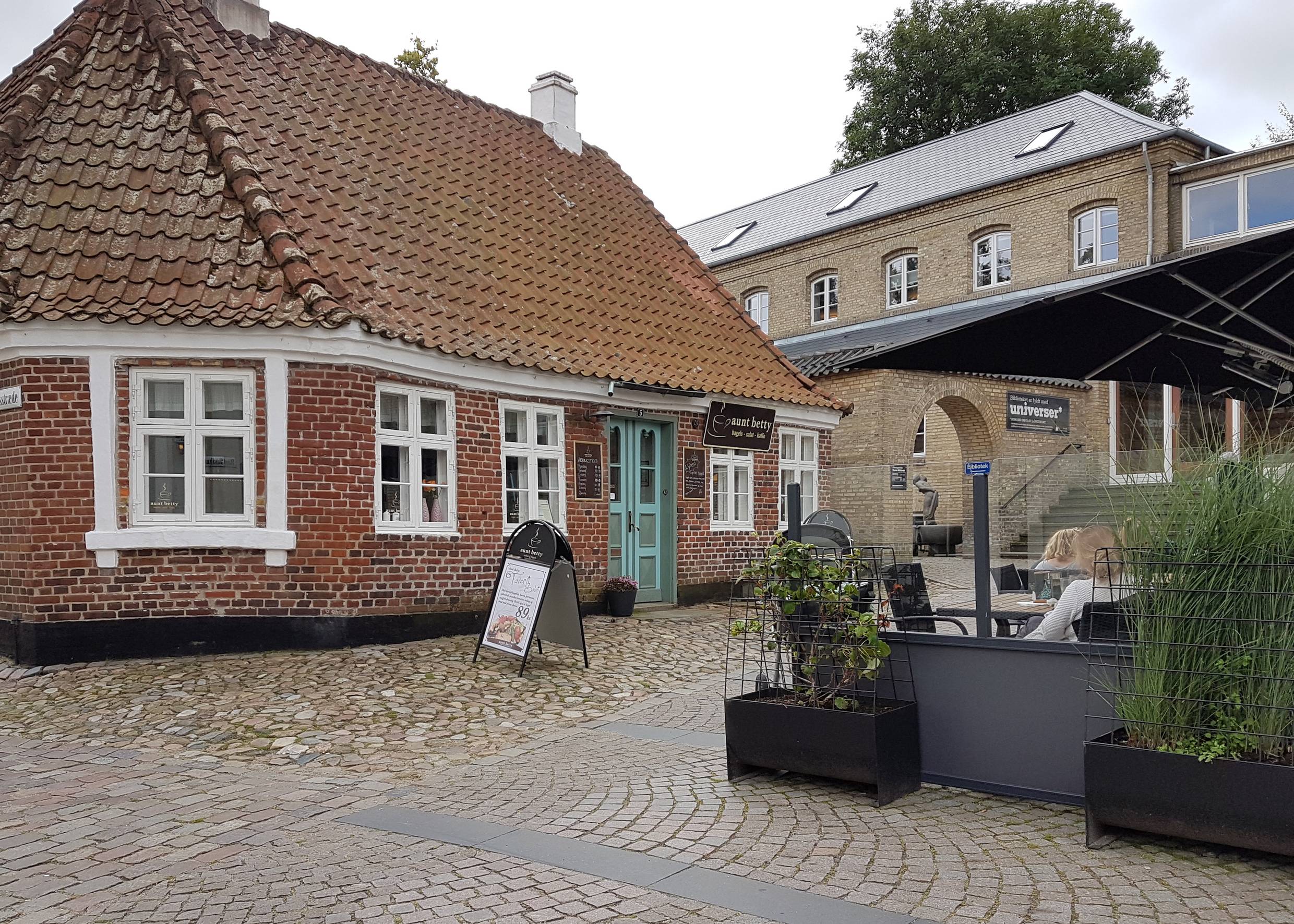 Kleines Häuschen vor dem Rathaus mit einem Lokal 