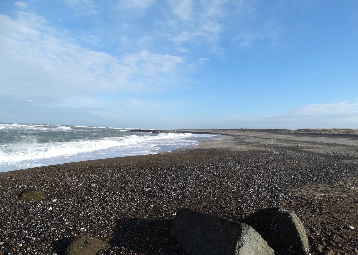 Sehr steiniger Strand in einer langen Bucht