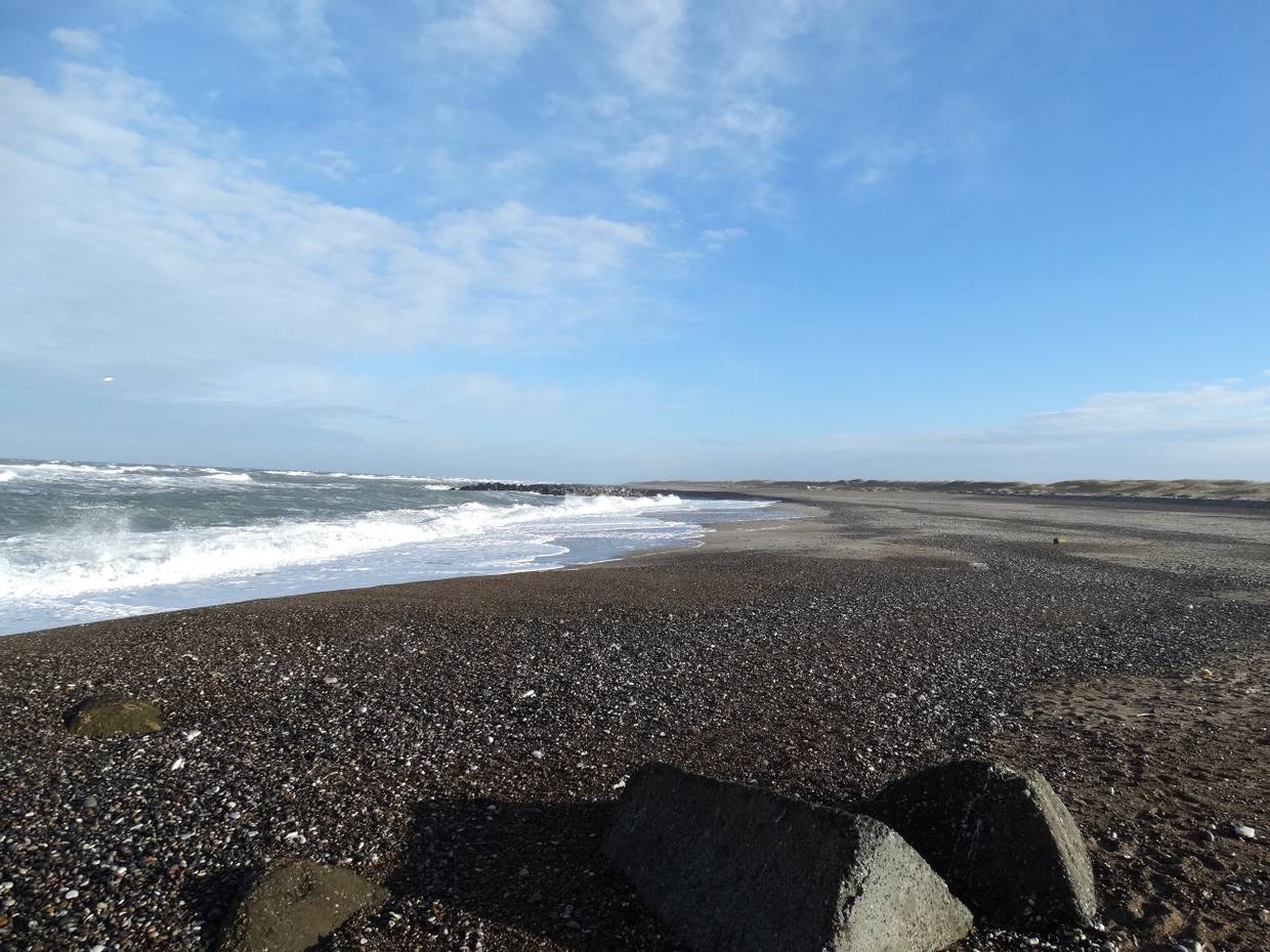 Sehr steiniger Strand in einer langen Bucht