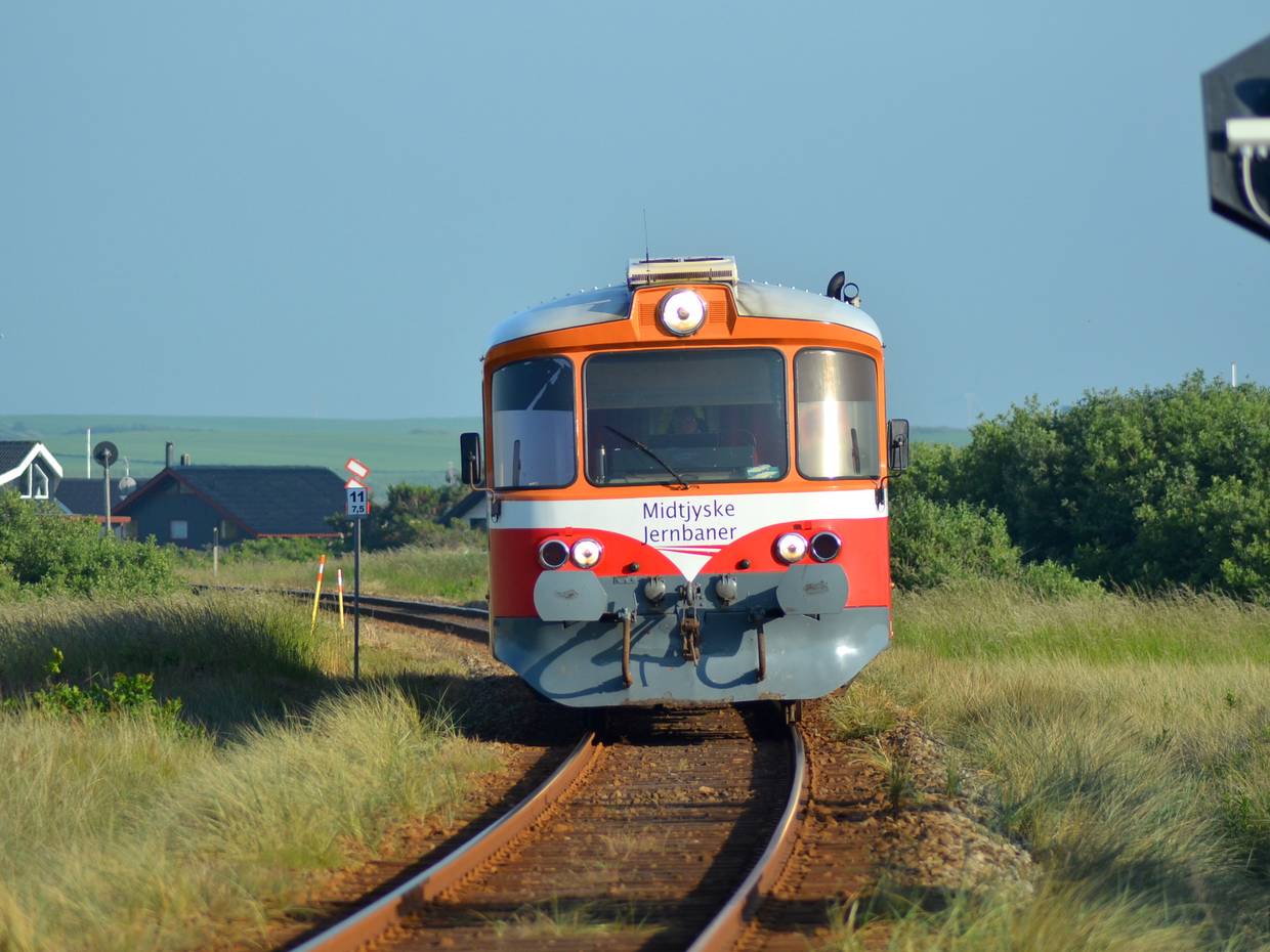 Ein Schienenbus auf einer einspurigen Strecke zwischen den Ferienhäusern