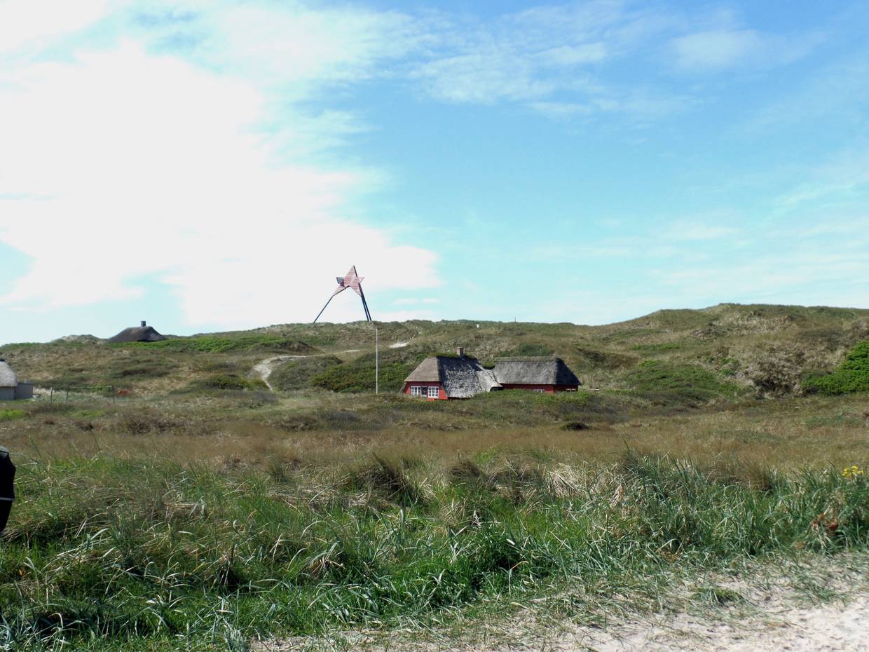 Seezeichen auf den Dünen, davor Ferienhäuser