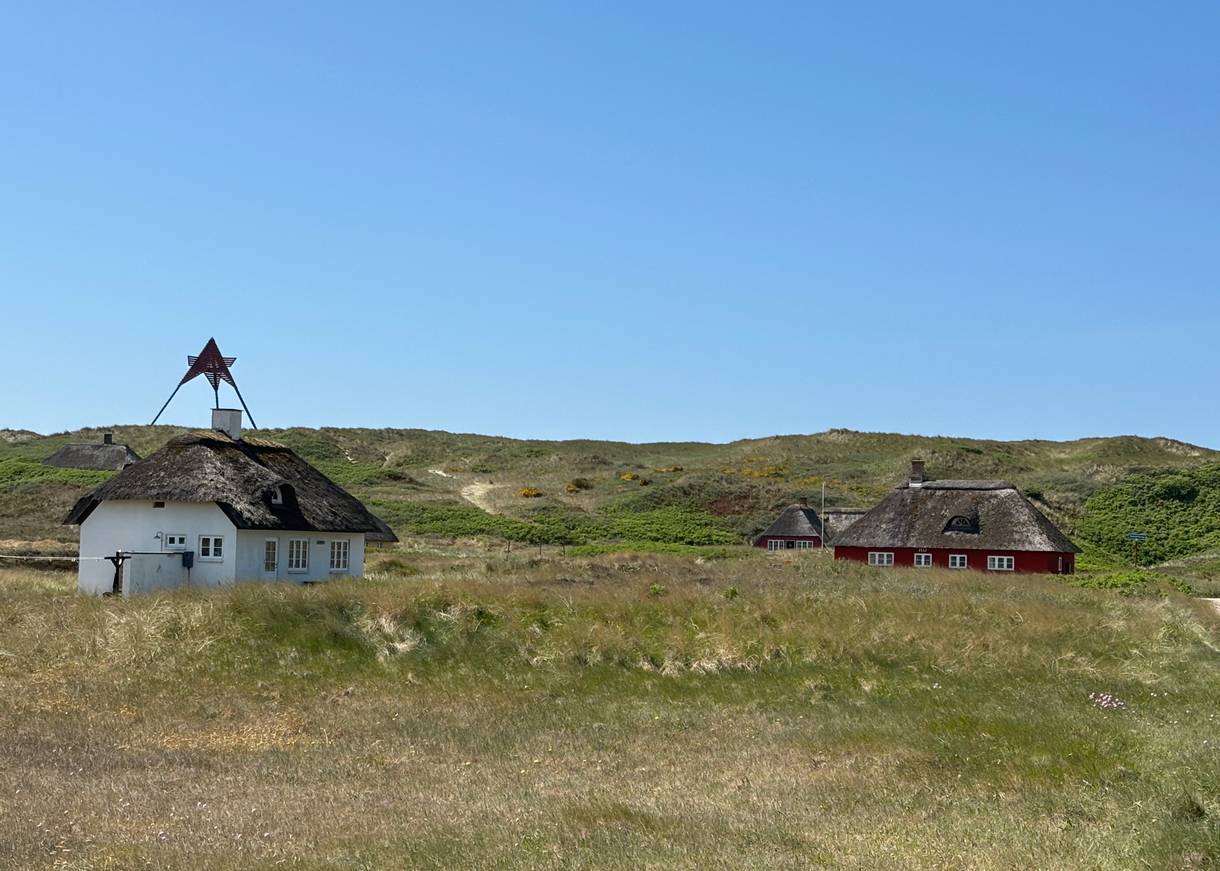 Seezeichen auf den Dünen, davor Ferienhäuser