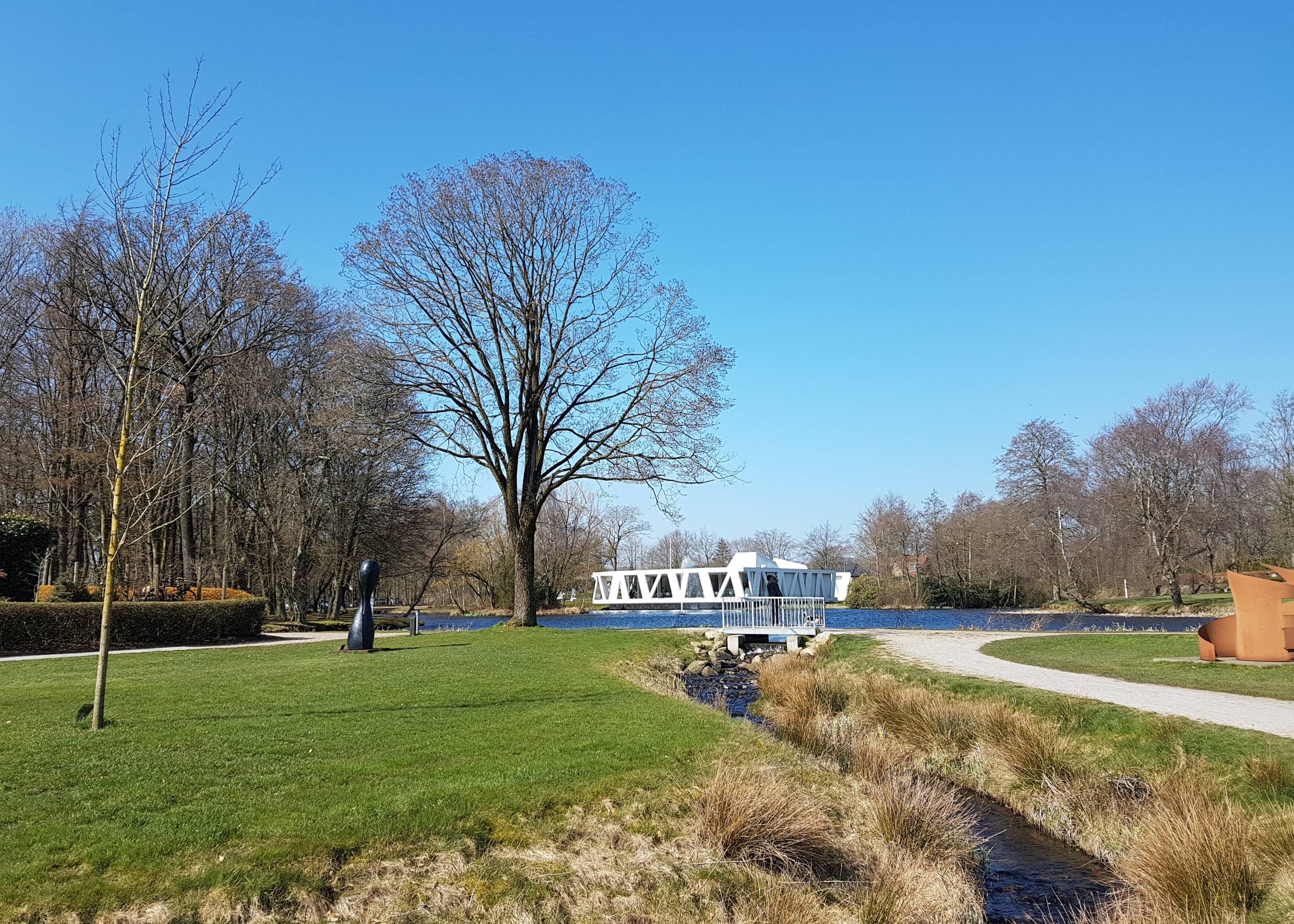 Parkfläche im Frühjahr, im Hintergrund ein weißes Gebäude
