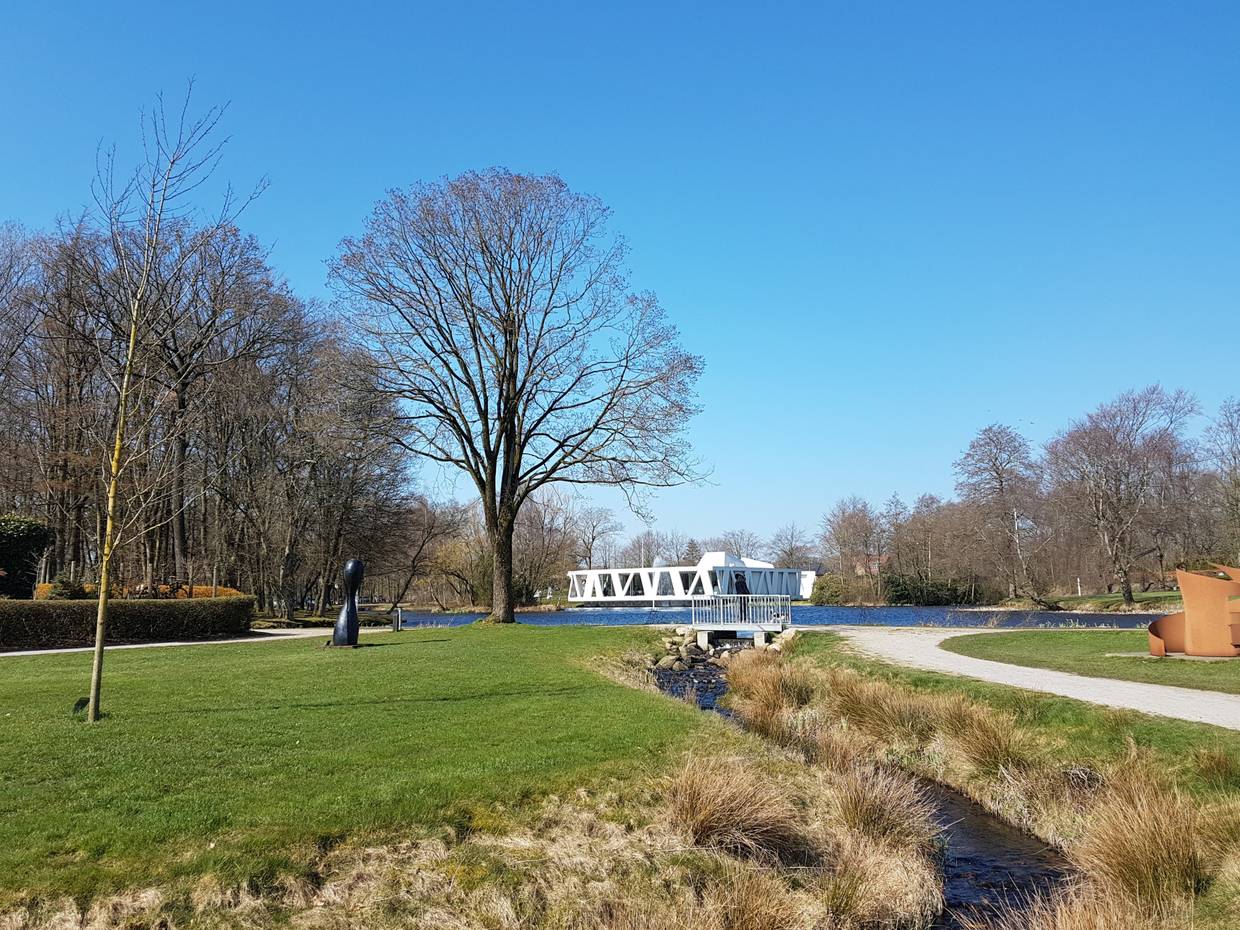 Parkfläche im Frühjahr, im Hintergrund ein weißes Gebäude